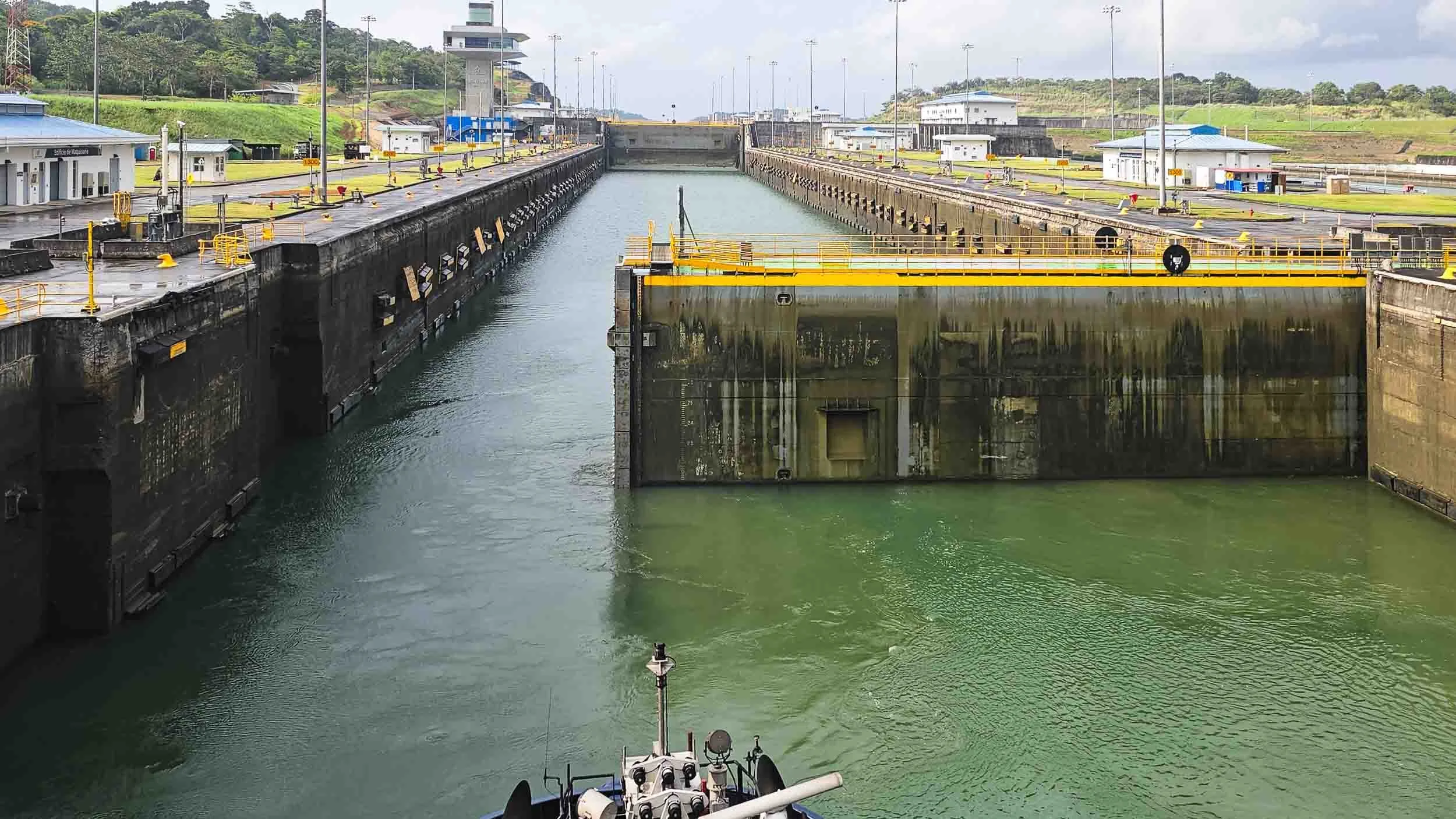 The rolling gate of the locks retracting into the side walls to allow passage for the ship.