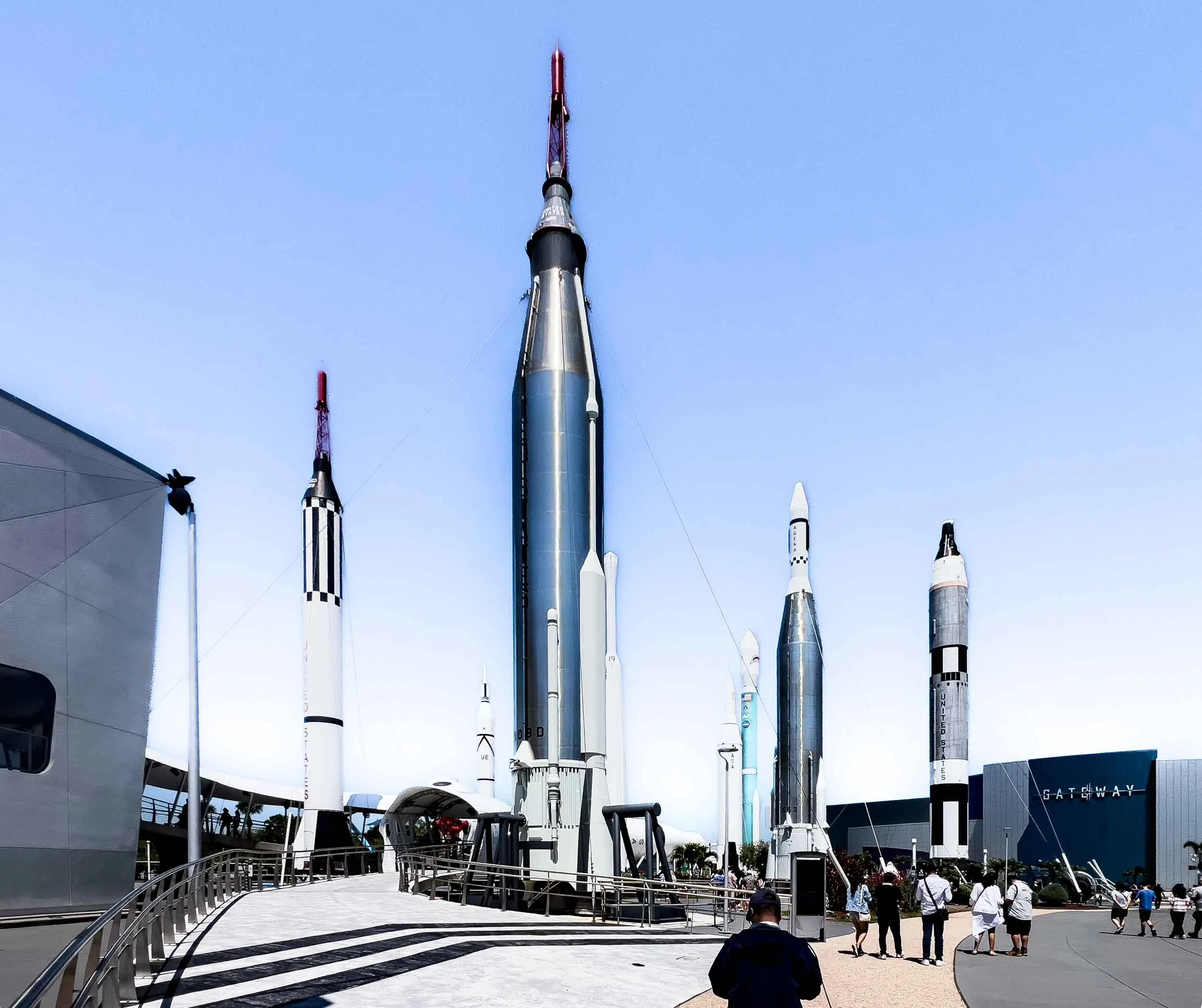 The tall center Tocket is Mercury-Atlas which launched John Glenn into orbit in 1962. The black-and-white checked rocket is Mercury-Redstone which launched America's first crewed suborbital spaceflights carrying Alan Shepard and Gus Grissom.
