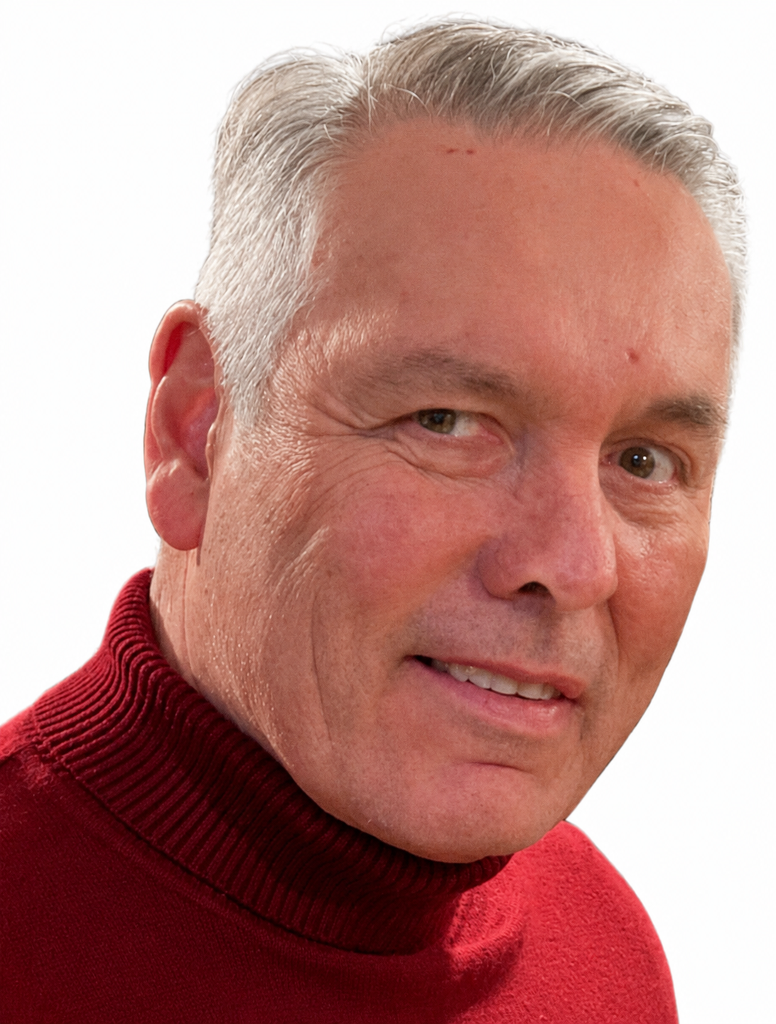 Close-up of a middle-aged man with gray hair wearing a red turtleneck, smiling and looking at the camera.