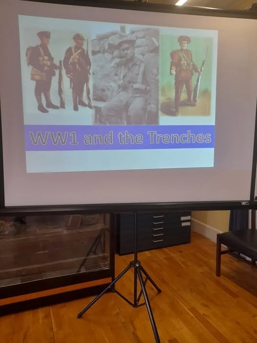 A presentation slide titled 'WW1 and the Trenches' featuring images of soldiers from World War I, including standing soldiers in uniform, a sitting soldier, and an illustrated soldier for educational purposes.