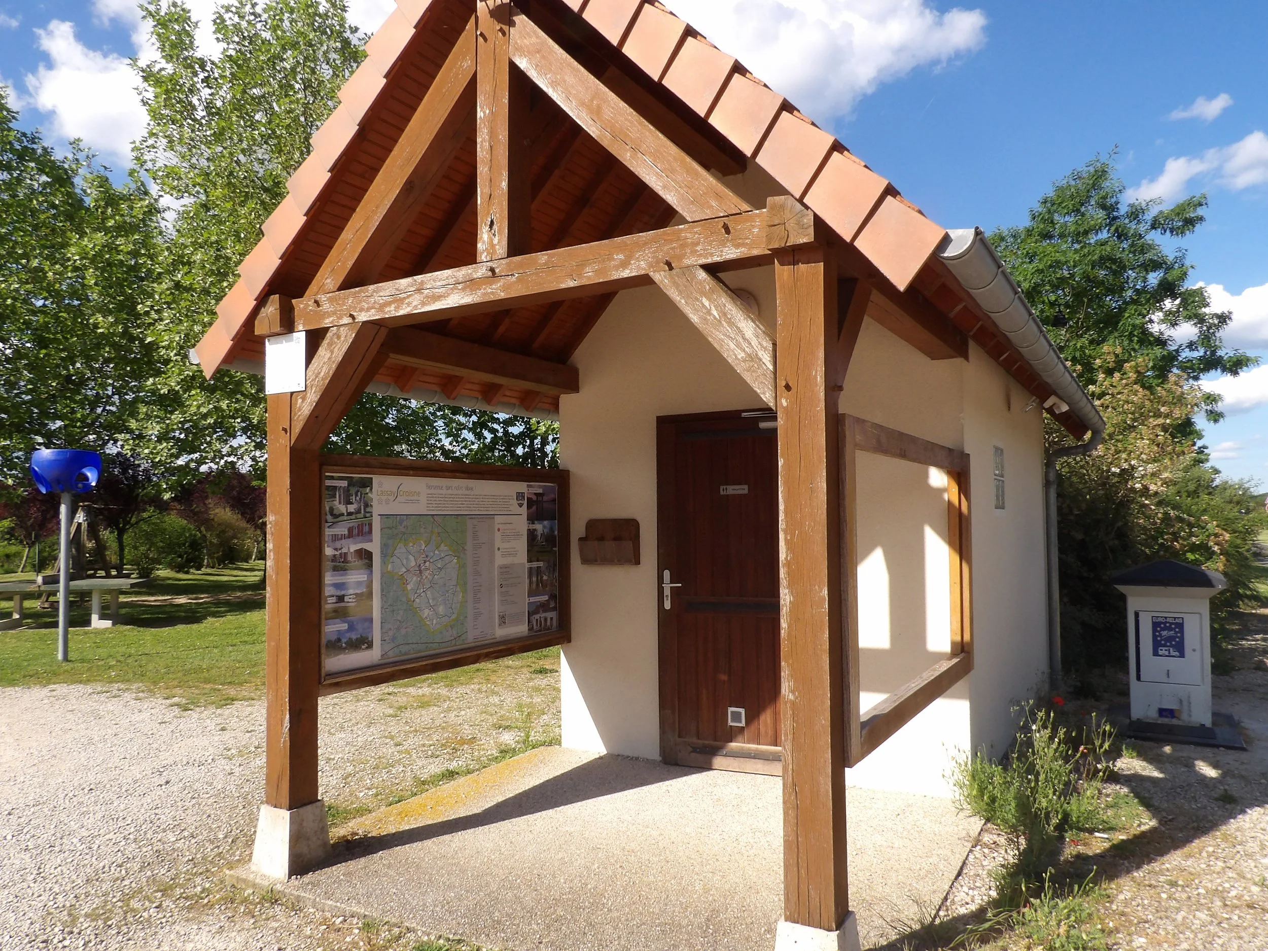 Toilettes publiques et panneau d'information touristique sur l'aide de jeux pour enfants de Lassay-sur-Croisne ©Maxime Roubalay