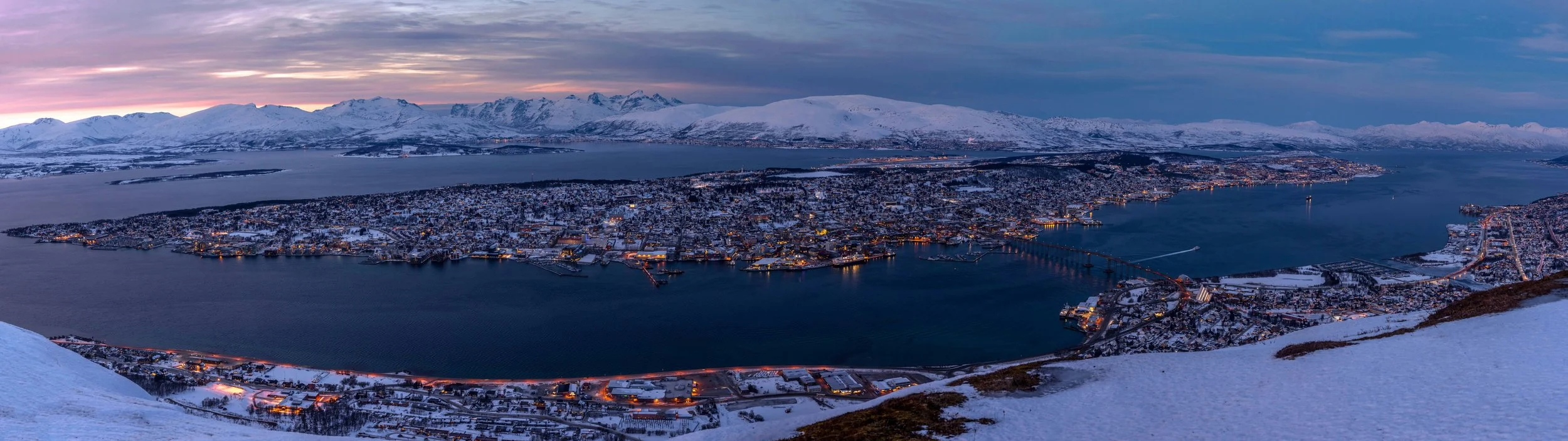Panoramautsikt over Tromsø by med fjell og fjord, sett fra Fjellheisen