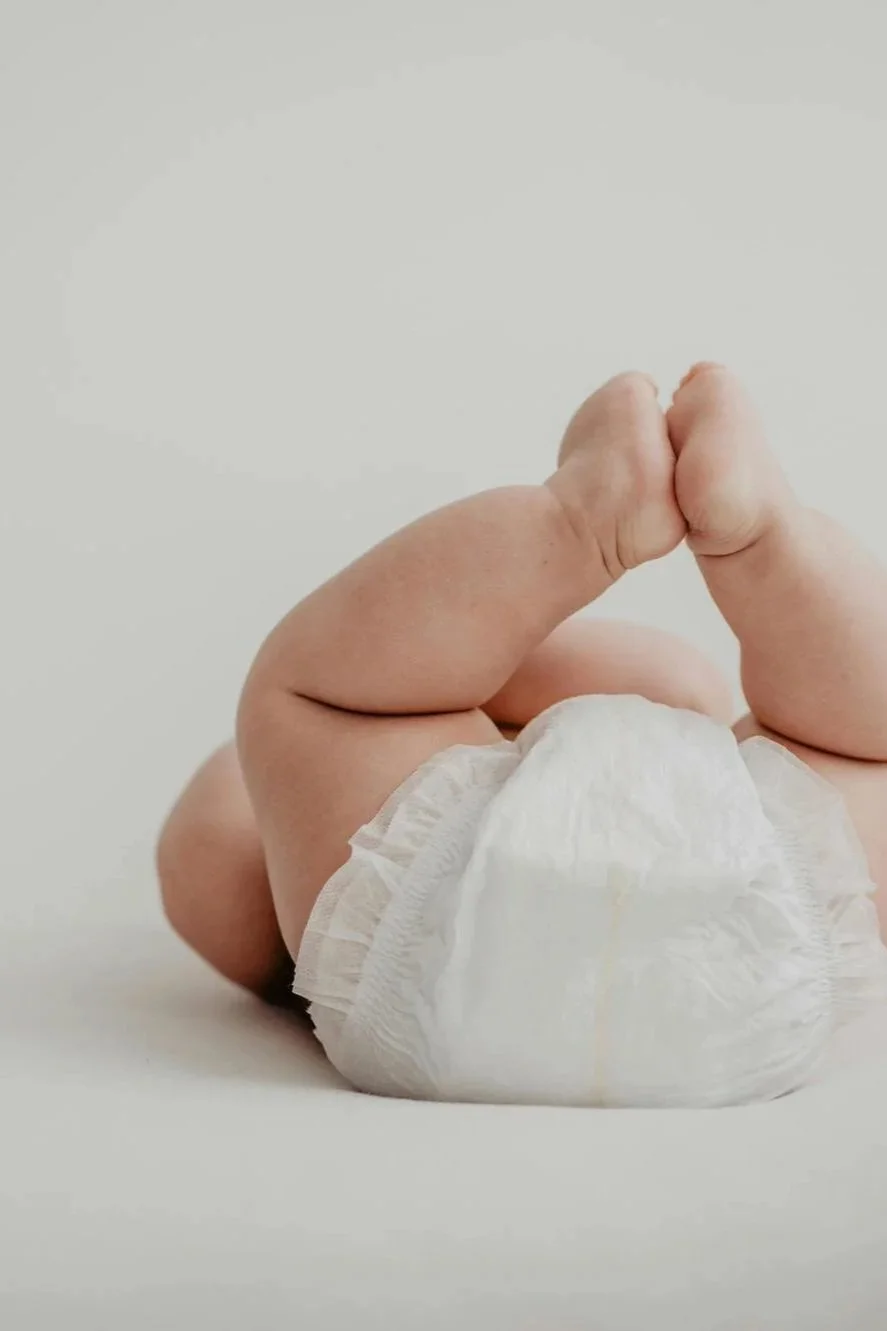baby in diaper with feet in the air