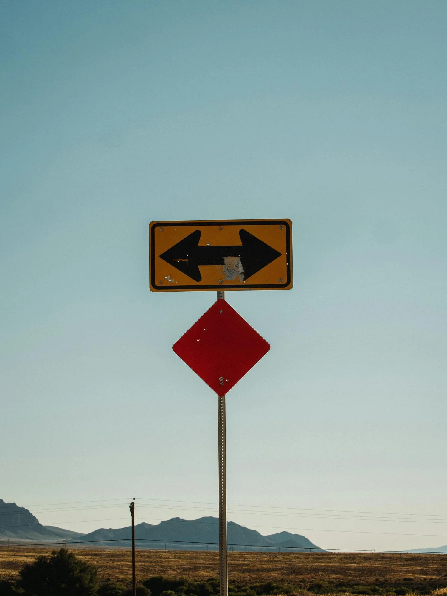 yellow traffic sign with arrows pointing both left and right