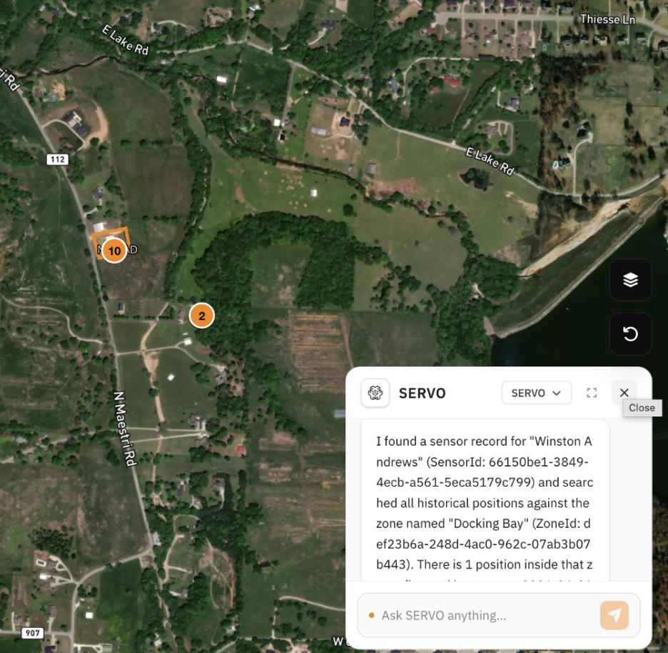 Satellite map of a rural area showing roads, green fields, trees, and a body of water along the right side. Notable roads include N Maestri Rd, E Lake Rd, and E Lake Ln. There are markers with numbers 2 and 10 indicating sensor locations, and a pop-up window with sensor data information.