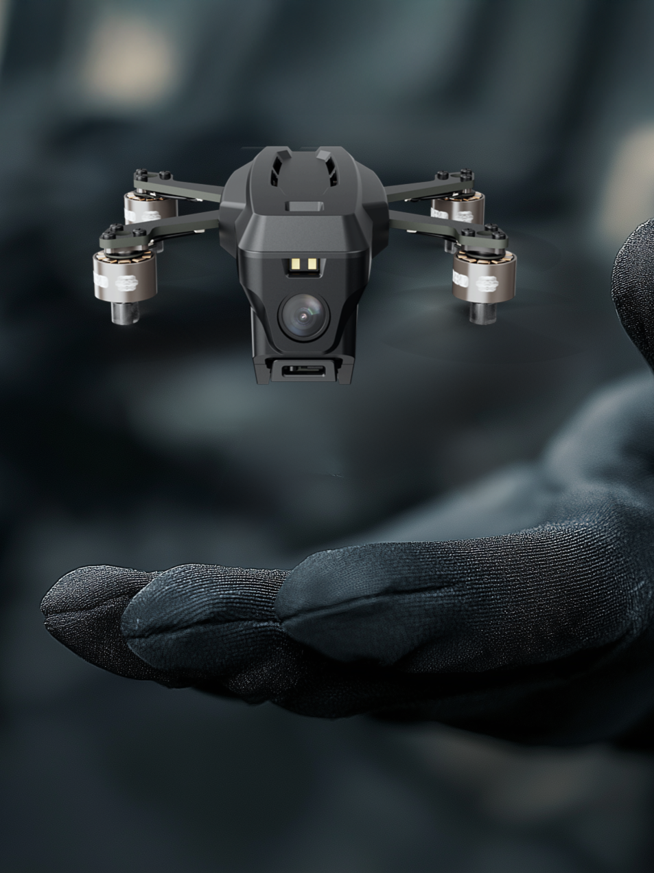 Close-up of a small black drone with a camera hovering above a person's gloved hand.