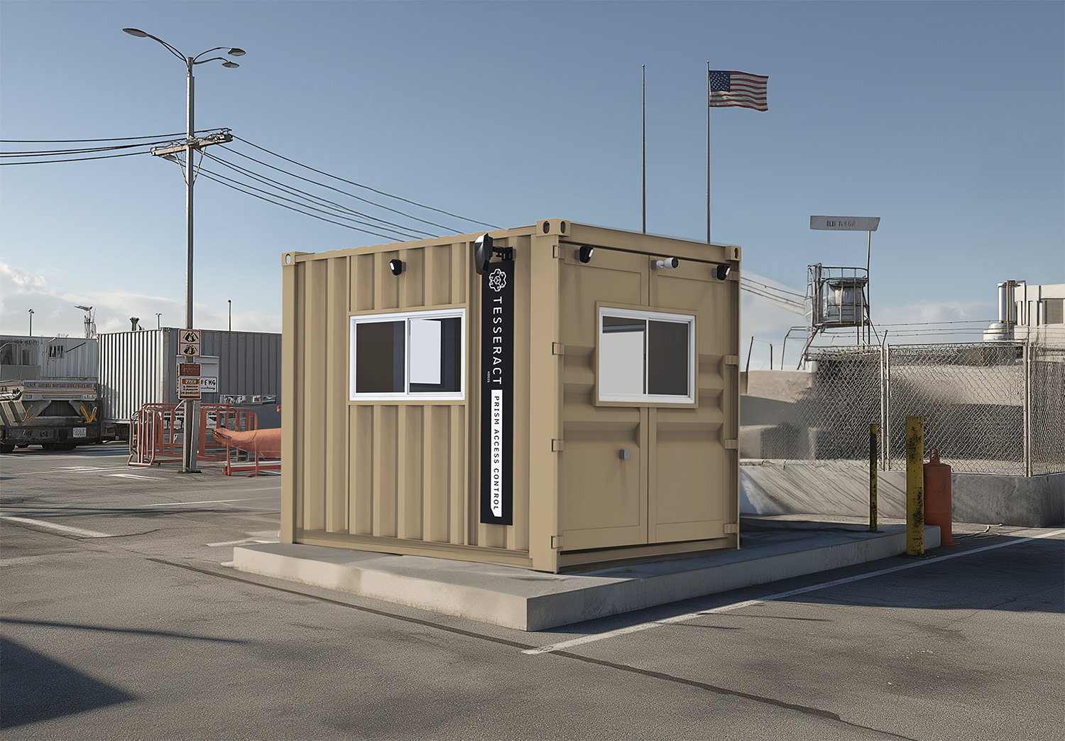 A beige modular security booth with two windows and a vertical sign that reads 'TESSERACT Prime Access Control,' situated in an industrial parking lot with barriers, chain-link fencing, and American flags in the background.