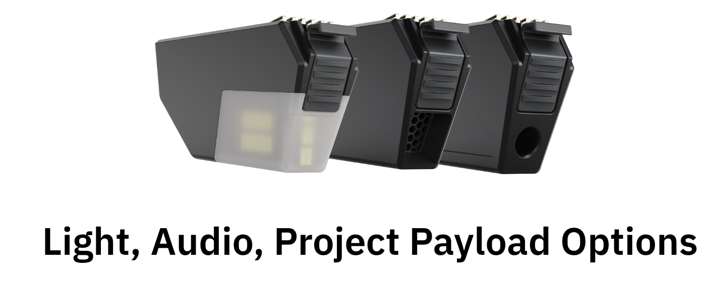 A series of black industrial projectors arranged in a row, with one white component on the left. The image has a caption that reads 'Light, Audio, Project Payload Options.'