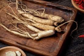 Fresh ginseng roots on a wooden cutting board.