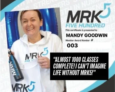 Certificate with a photo of a smiling woman holding a certificate, logo for MRK5, and a quote about completing nearly 1,000 classes.