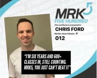 A smiling man holding a certificate for MRK5 Five Hundred driving school with a quote that says, 'I'm six years and 600+ classes in, still counting. MRK5, you just can't beat it.'