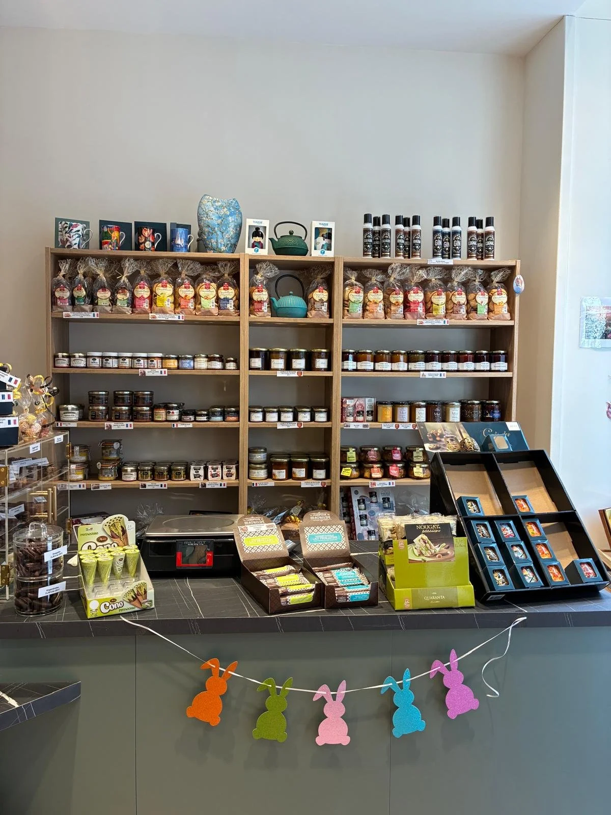 Rayon de sachets de biscuits, bocaux de confitures, étagères avec de la poussière, boîte à chocolats, décorations de Pâques