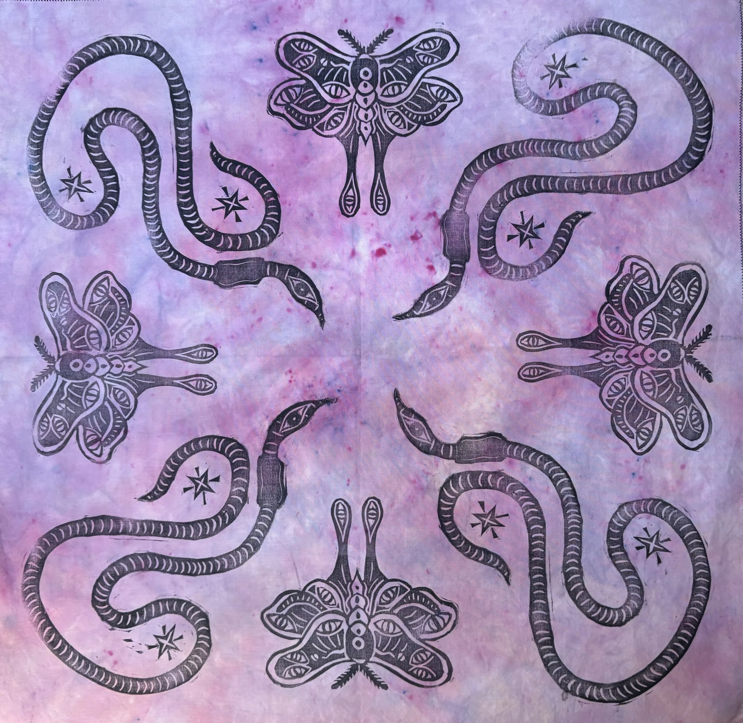 Black line drawings of snakes, moths, and star-like symbols arranged in a symmetrical pattern on a purple and pink tie-dye background.