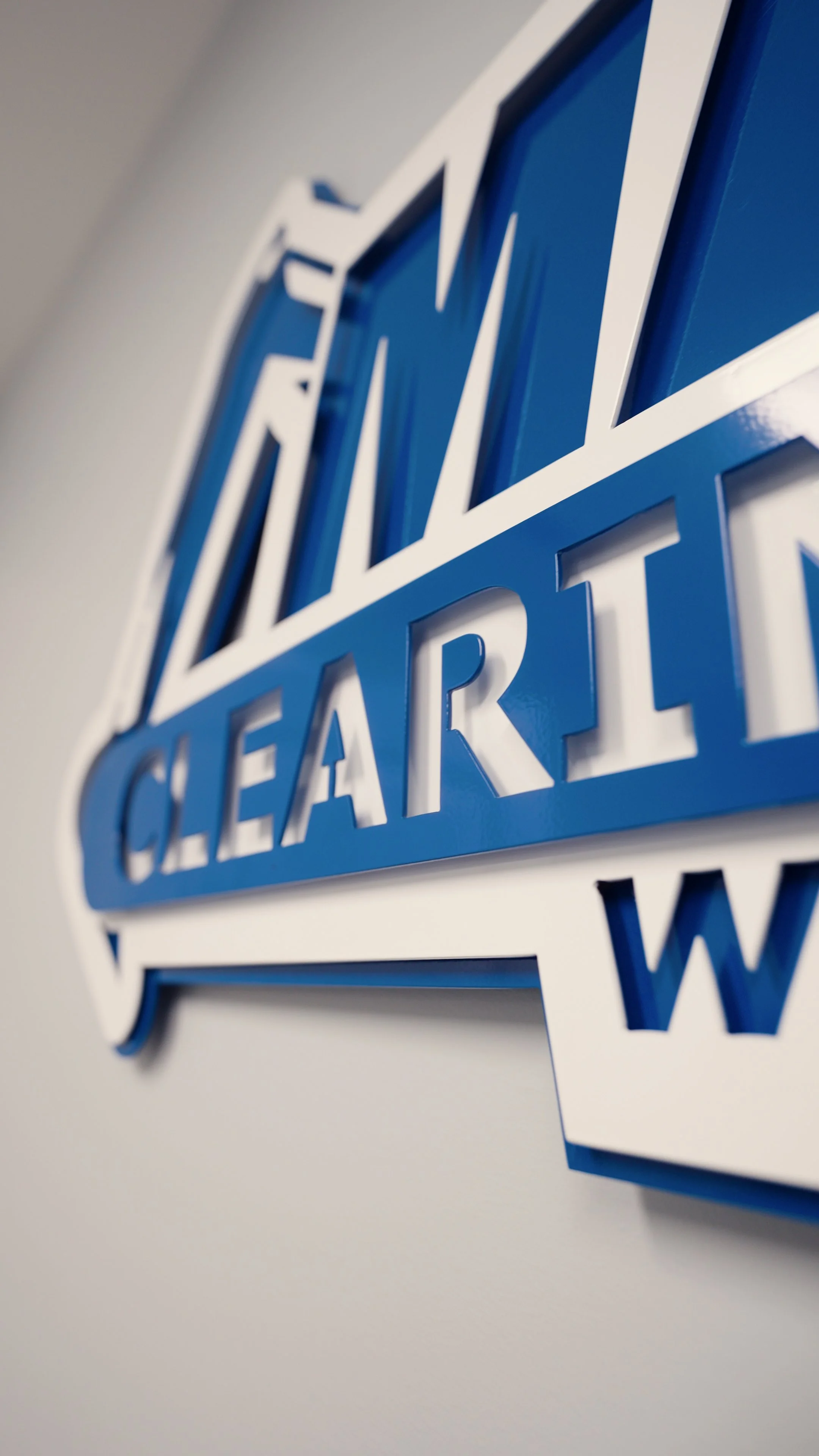 Close-up of a blue and white Chevrolet sign mounted on a wall.