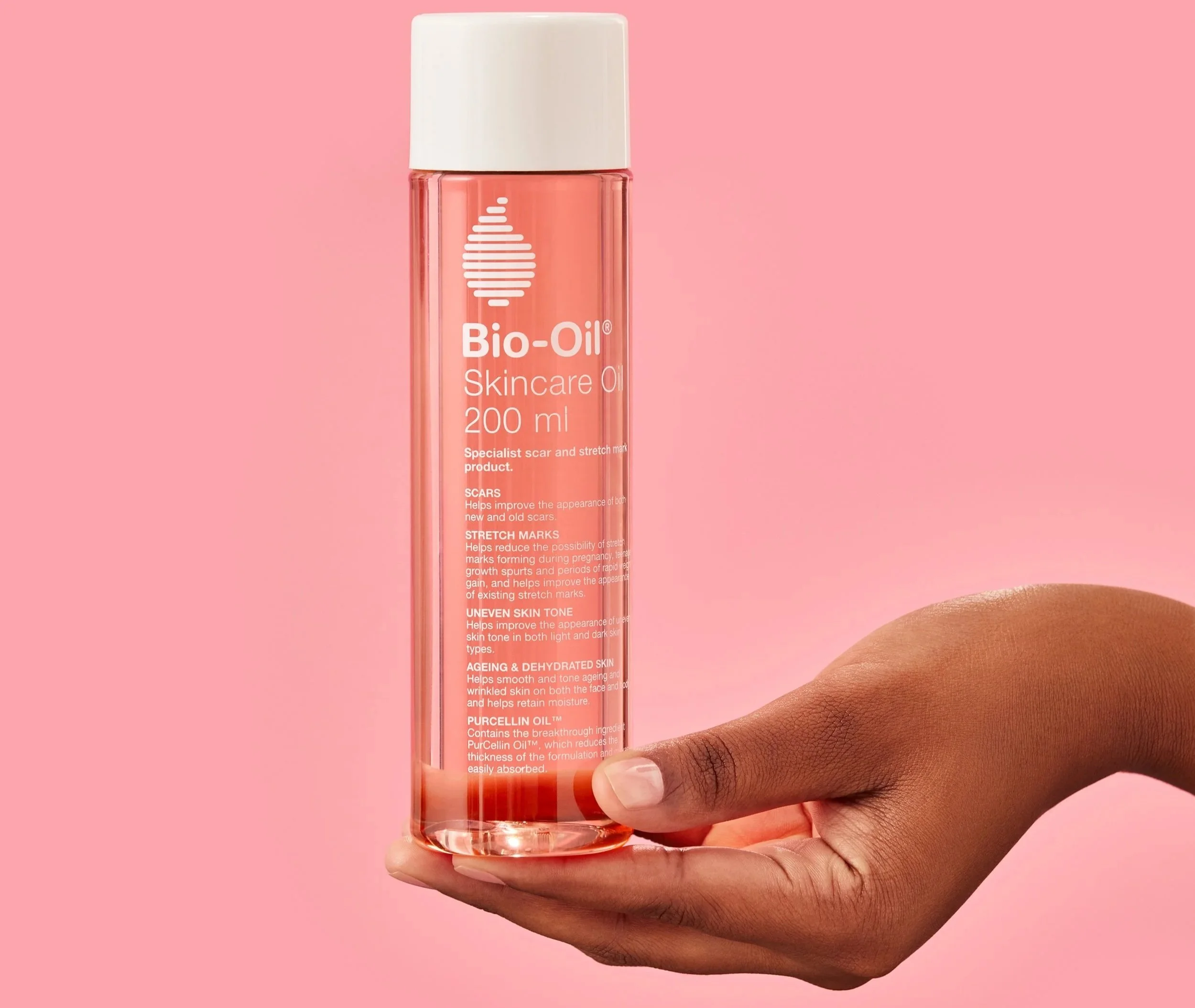 3D rendered Bio-Oil bottle composited into photo with hand on pink background