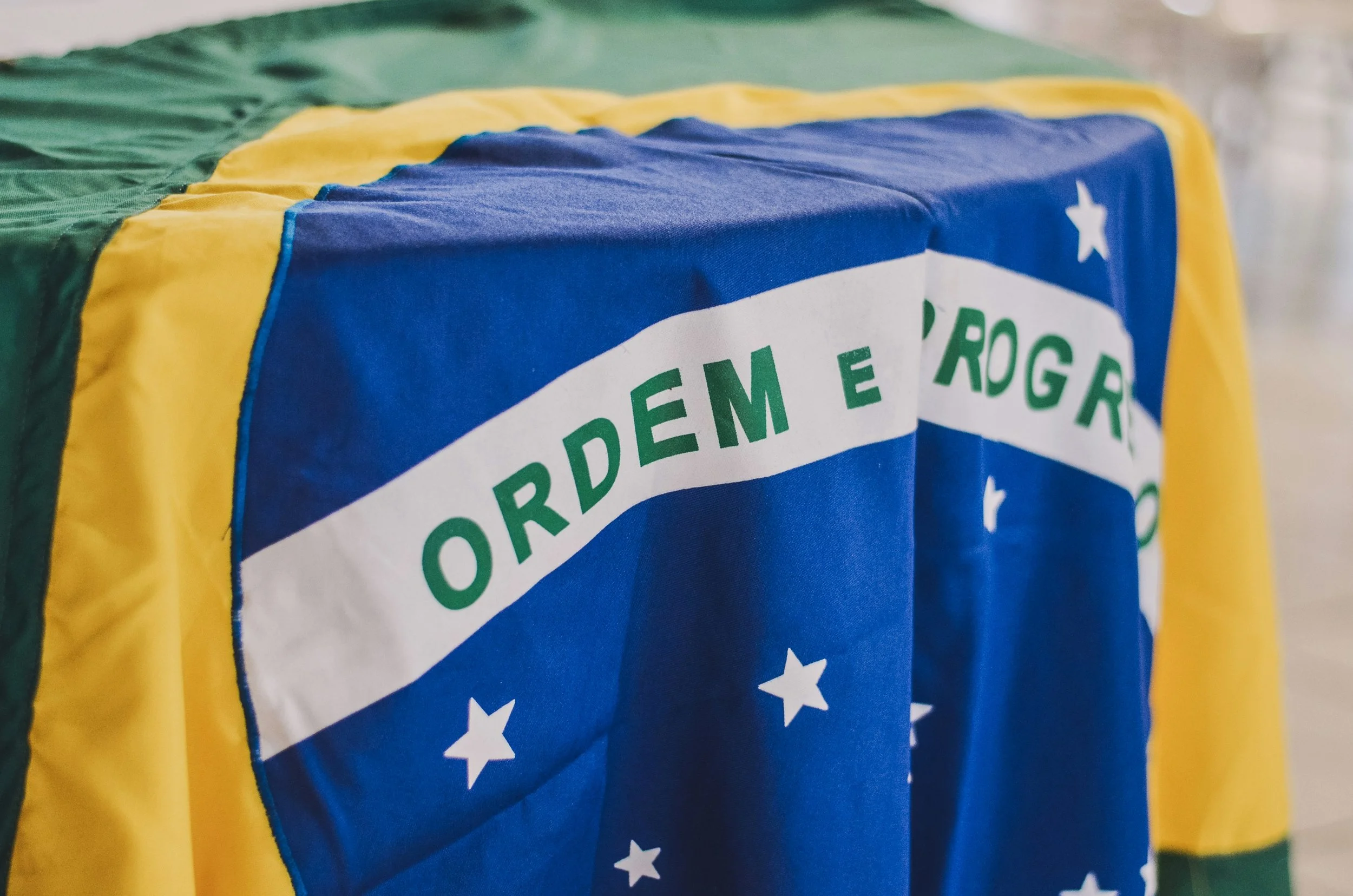 Close-up of a fabric with a design resembling the Australian flag, featuring green, yellow, blue, and white colors with stars.