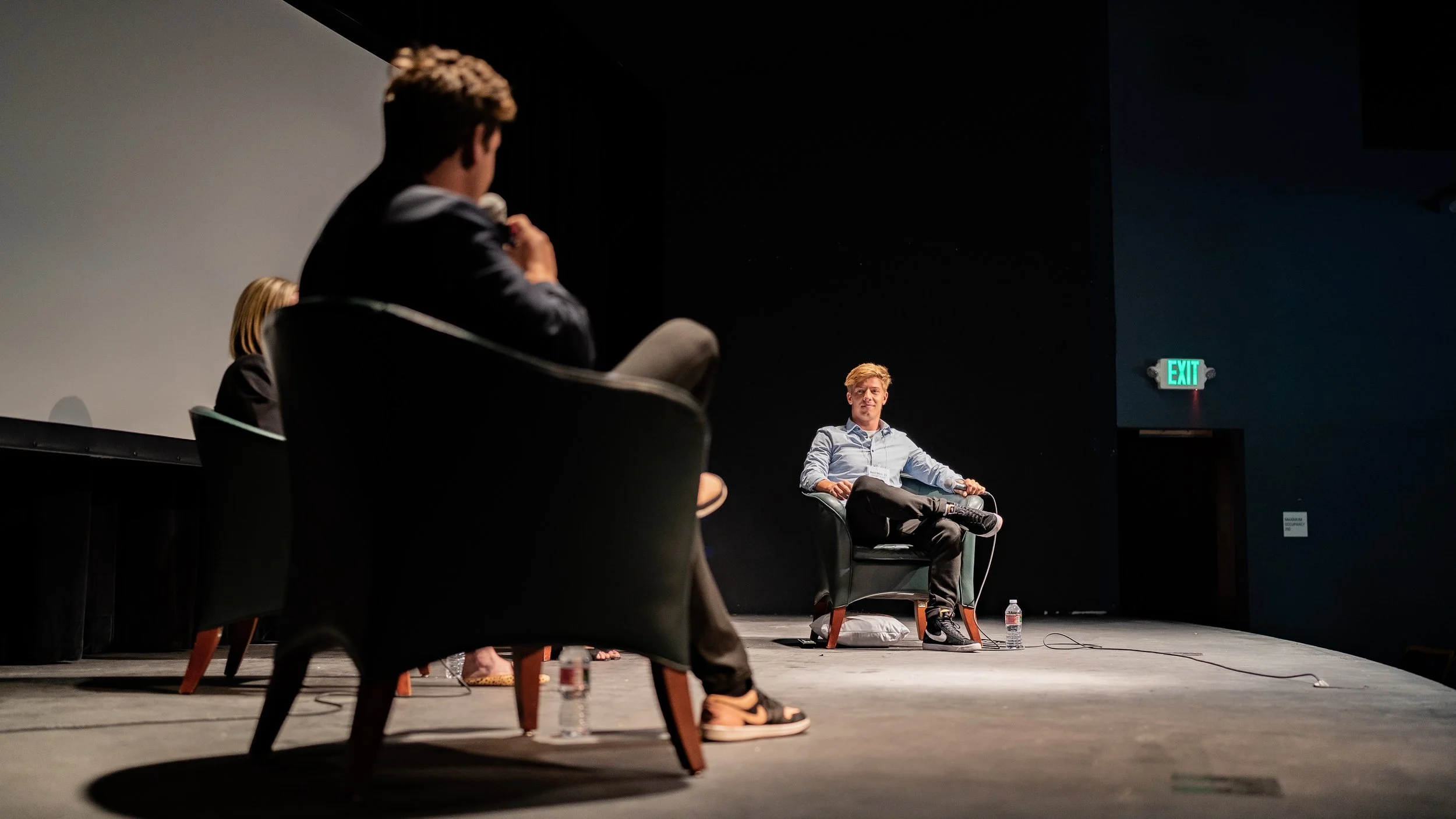 Basil Merk als professioneller Moderator auf einer Unternehmensveranstaltung – spezialisiert auf Vertrieb und Leadership-Events in einer Paneldiskussion, die er leitet