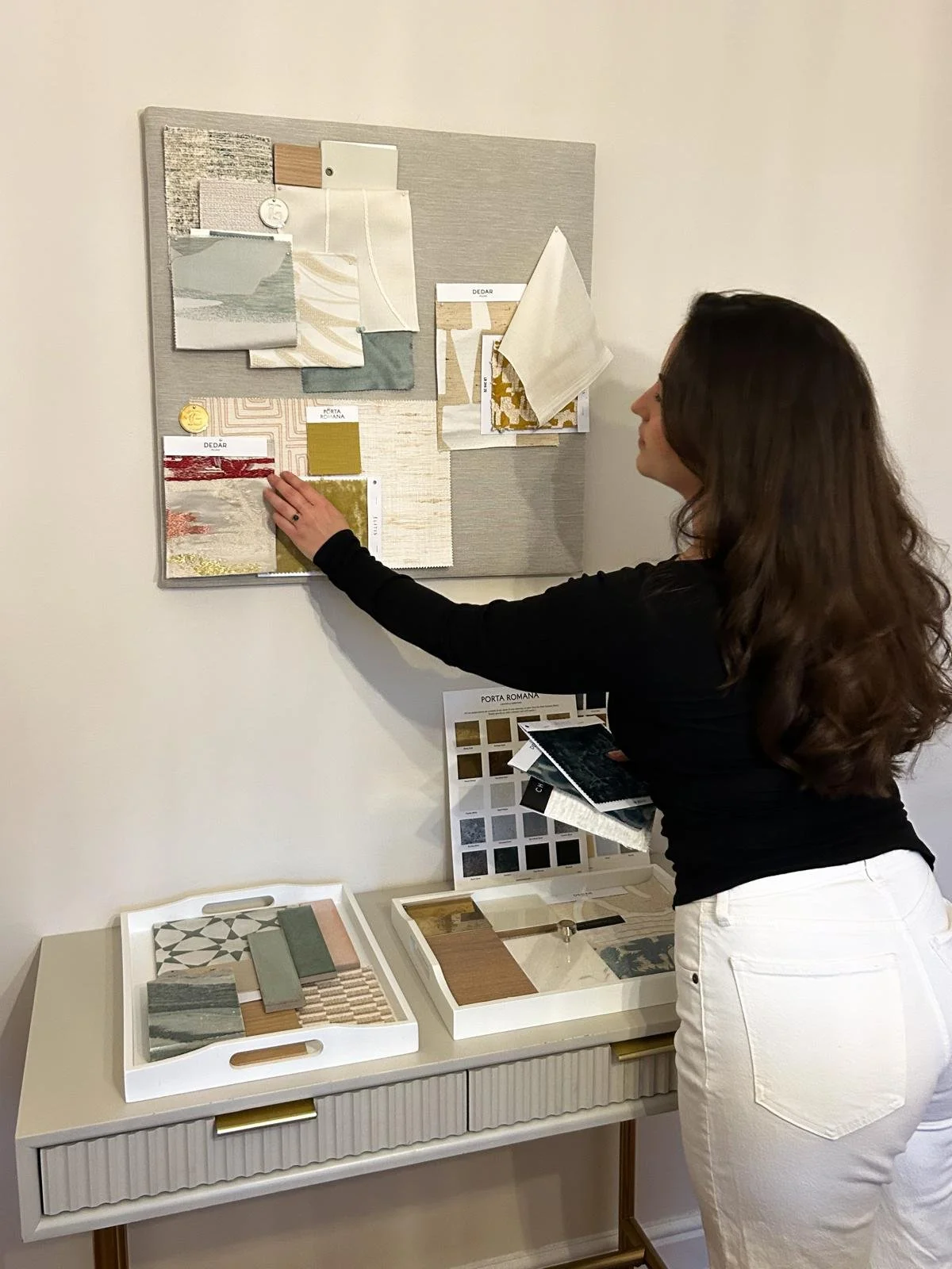 fabric samples and paint swatches on a wall display in a home decor or interior design setting.