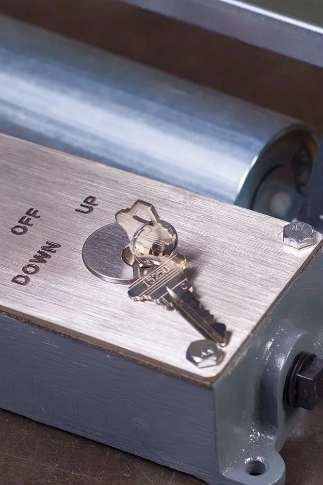 Close-up of a metal device with a key inserted into a lock, with the words 'OFF,' 'DOWN,' and 'UP' labeled around the keyhole.