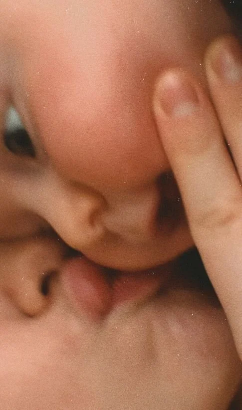 Close-up of two babies crying and touching each other's faces.