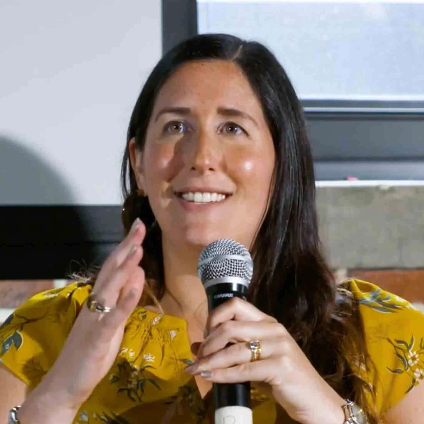 Cara Hogan, fractional CMO, speaks at an event on marketing strategy.