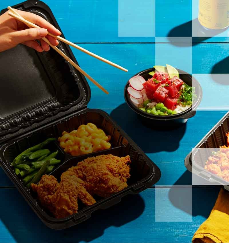 A variety of foods on a blue table including salad, pasta, chicken, dessert, and drinks.