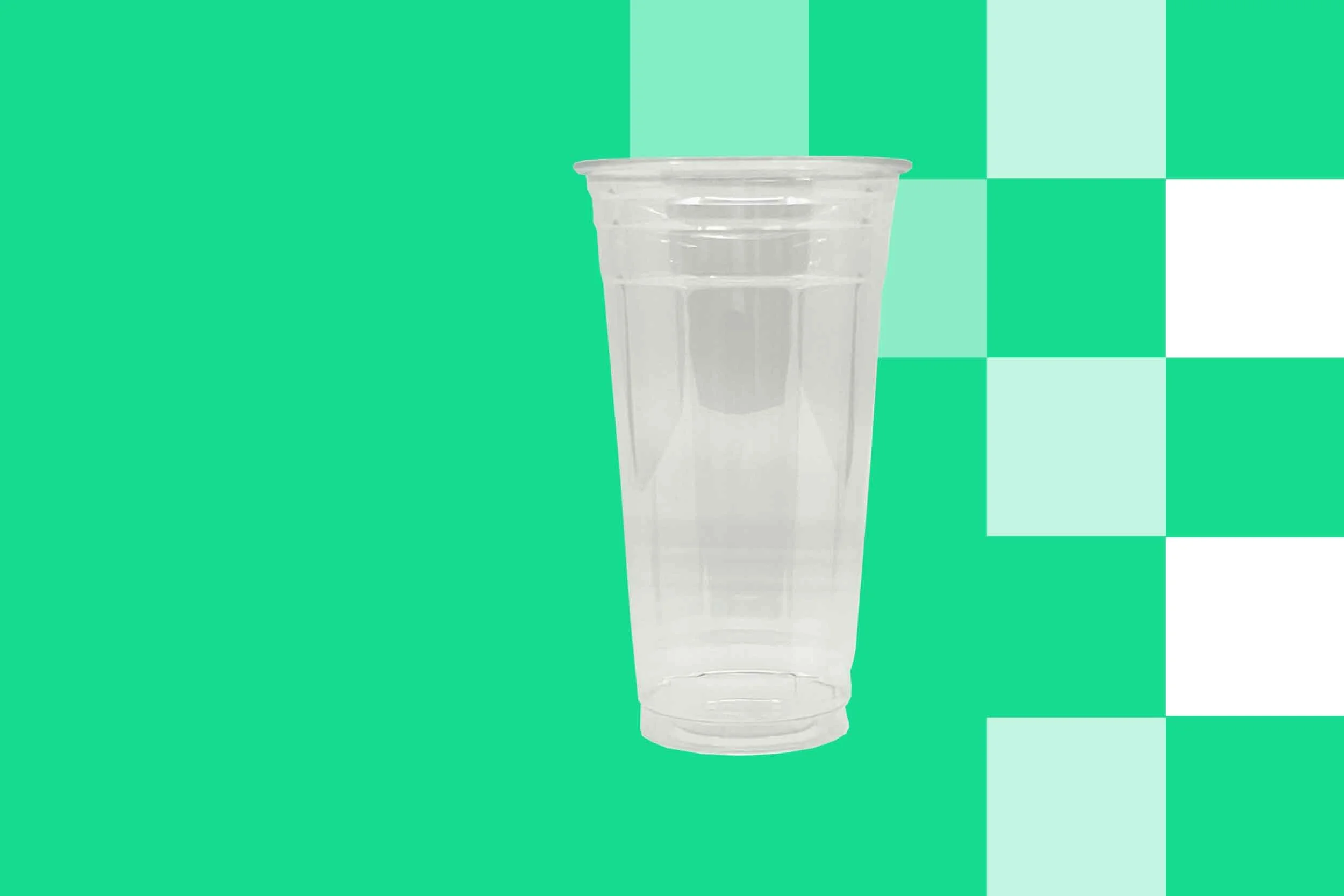 Empty clear plastic cup against a patterned green background.