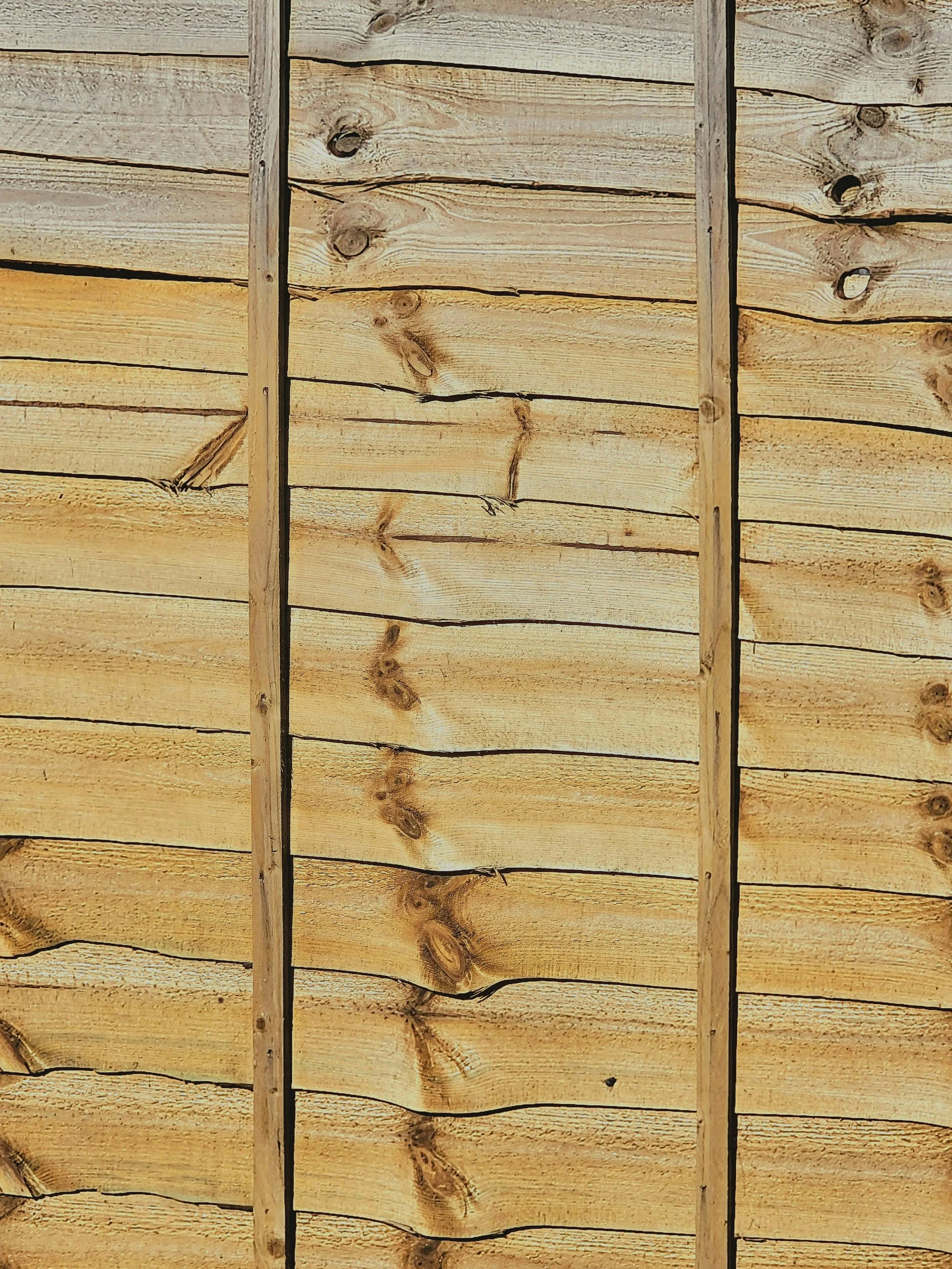 Close-up of a wooden wall with horizontal planks and vertical support beams.