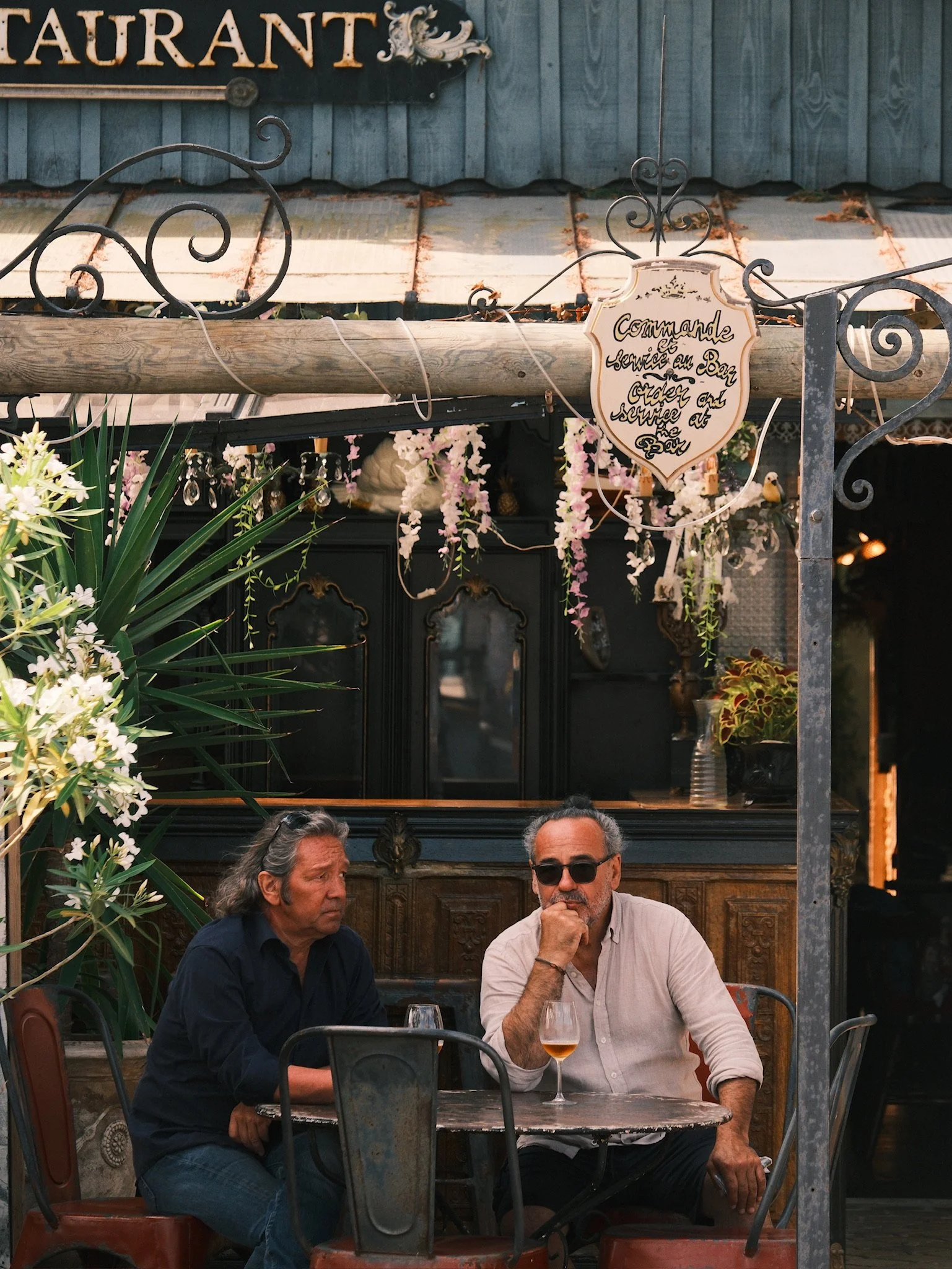 restaurant photo of two men enjoying a drink in scenic outdoor restauarant 