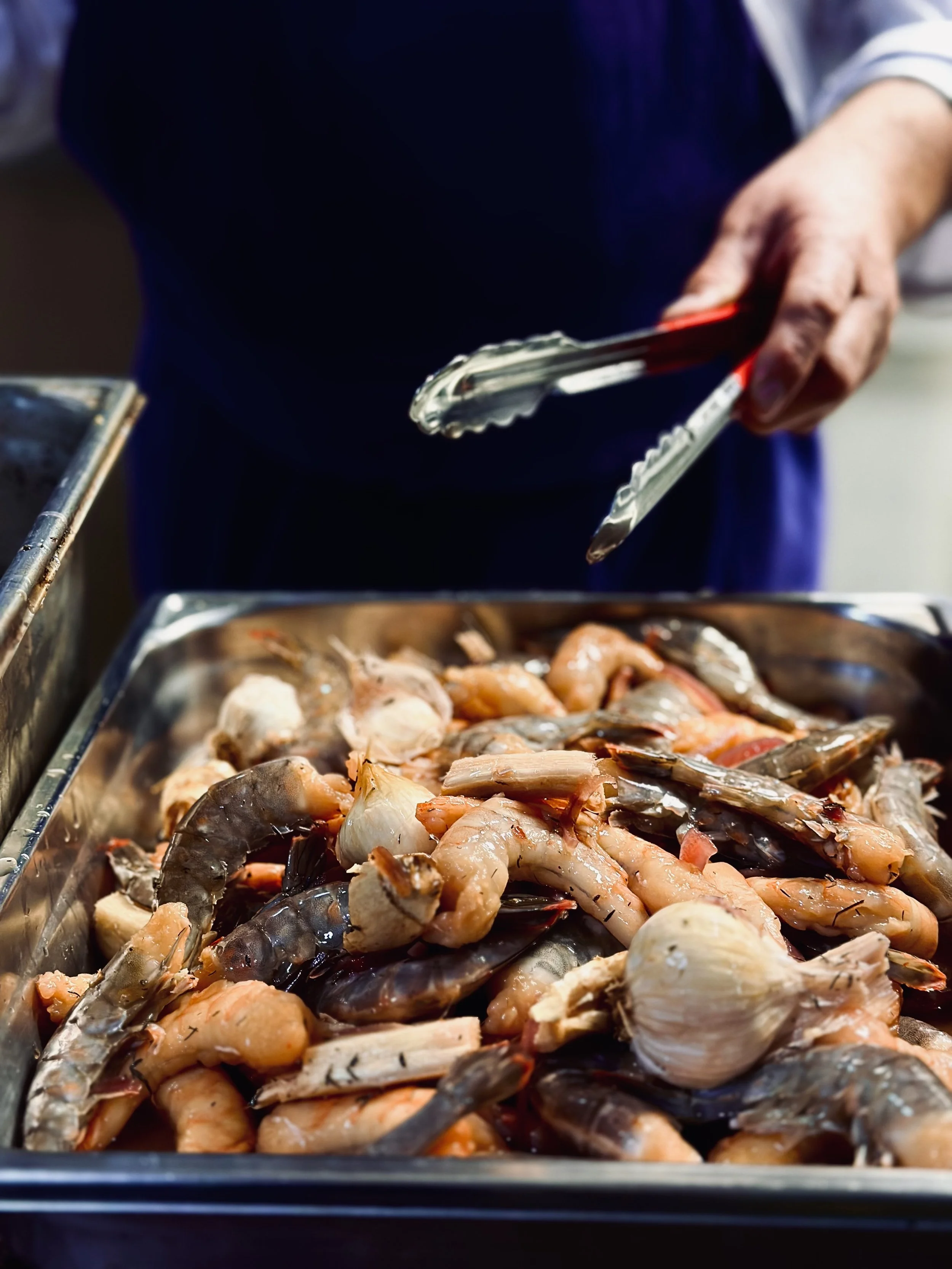 Chez Jaillet Lyon 6 | Préparation d'un plat de fruits de mer, crevettes, moules et d'autres coquillages, en cuisine par le chef cuisinier du Bistrot à Lyon 6