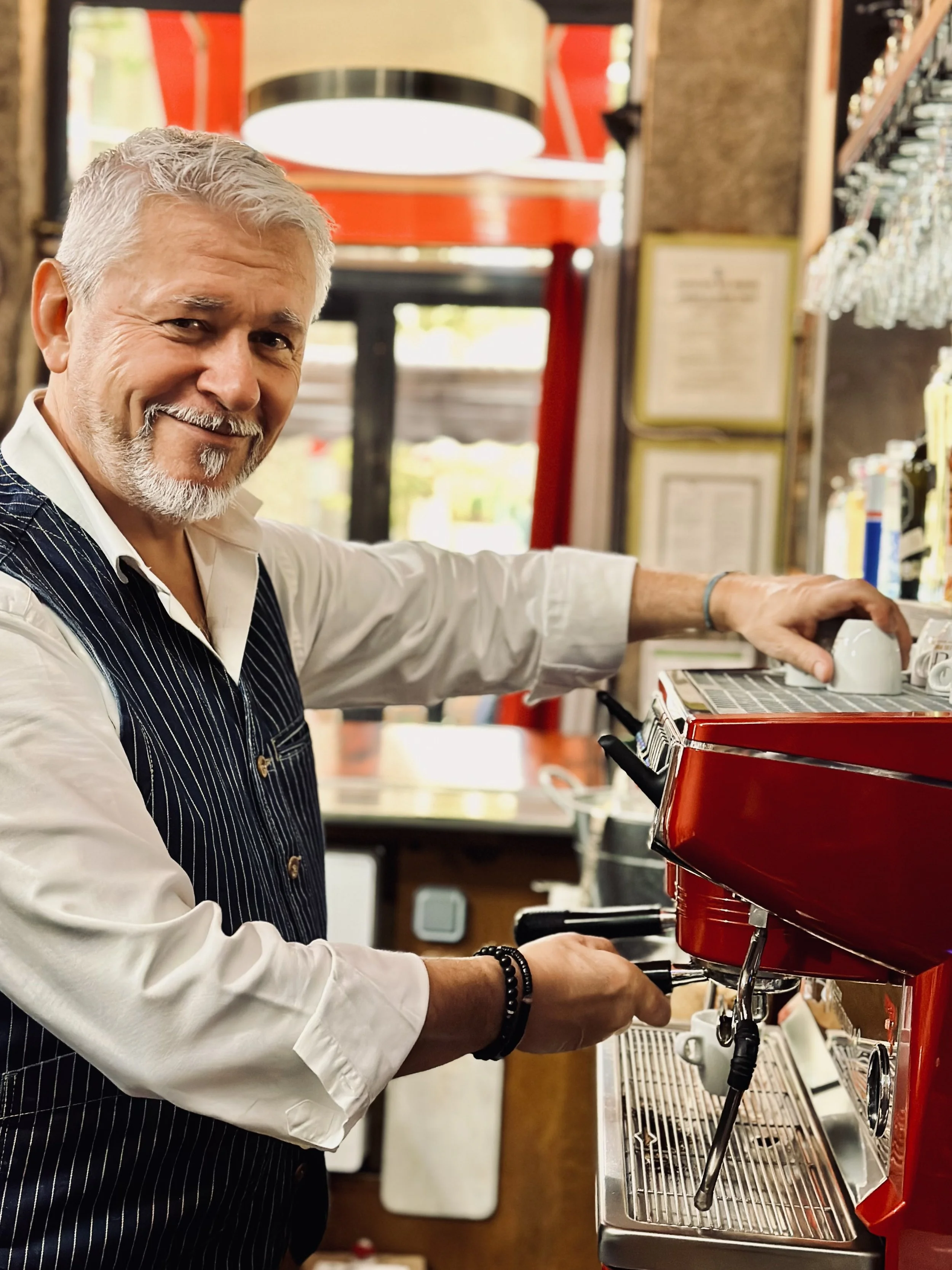 Chez Jaillet Lyon 6 | Didier Jaillet prépare un café au bistrot Lyon 6, devant une machine à espresso rouge.