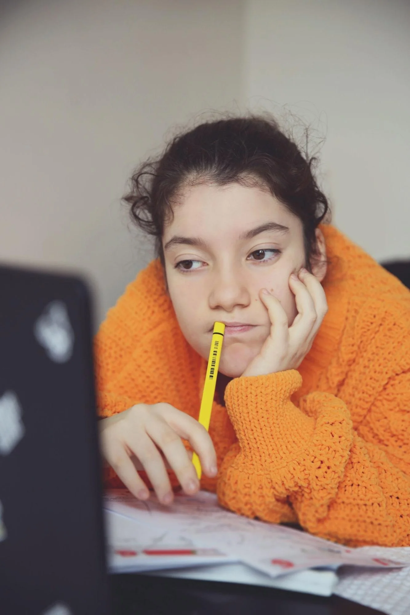 Student working on homework with a laptop during an online tutoring session.