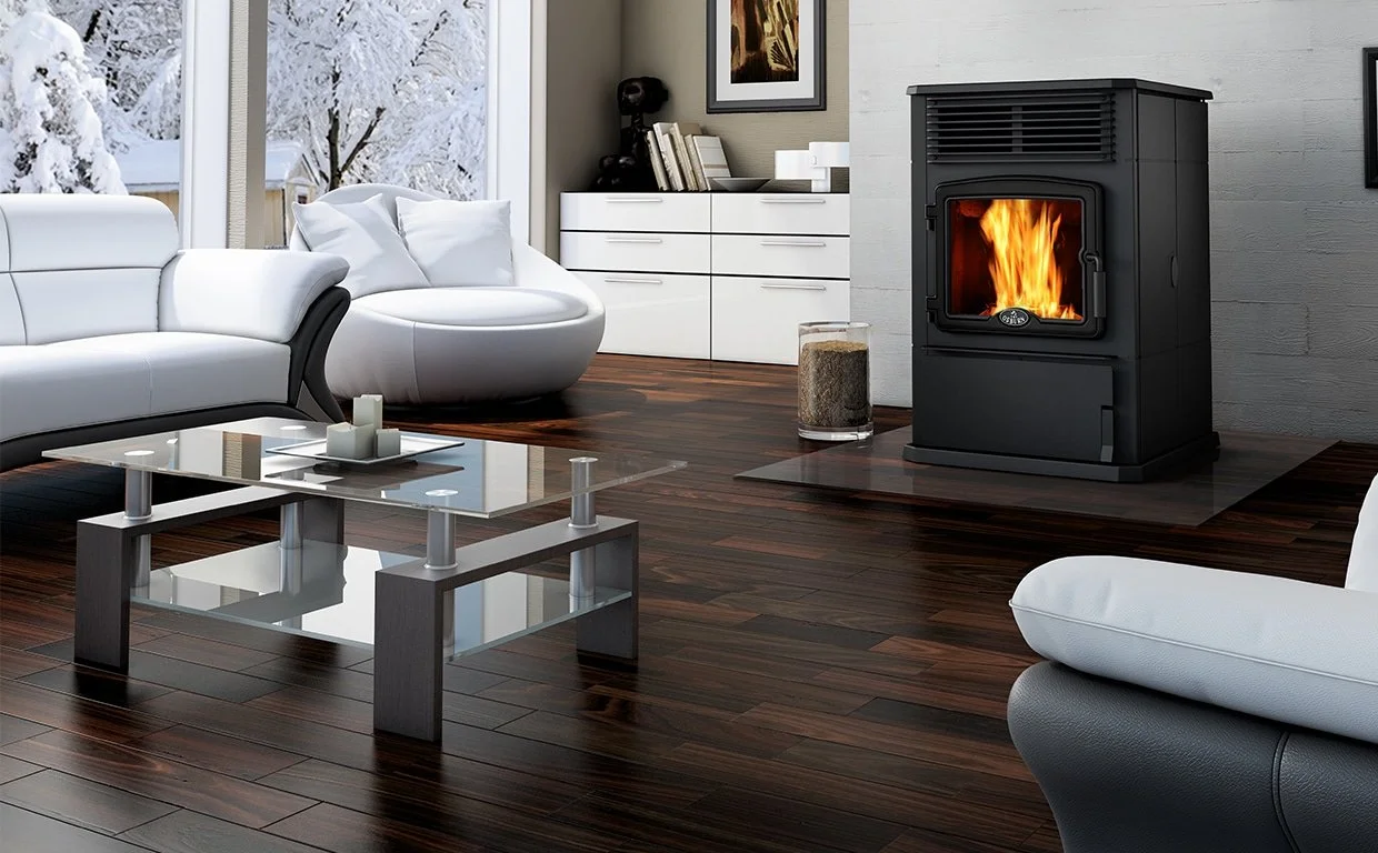 Living room with white modern furniture, a fireplace with a fire burning, a glass-top coffee table with candles, and a view of a snowy landscape outside through large windows.