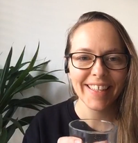Kristin smiling while holding a drink.