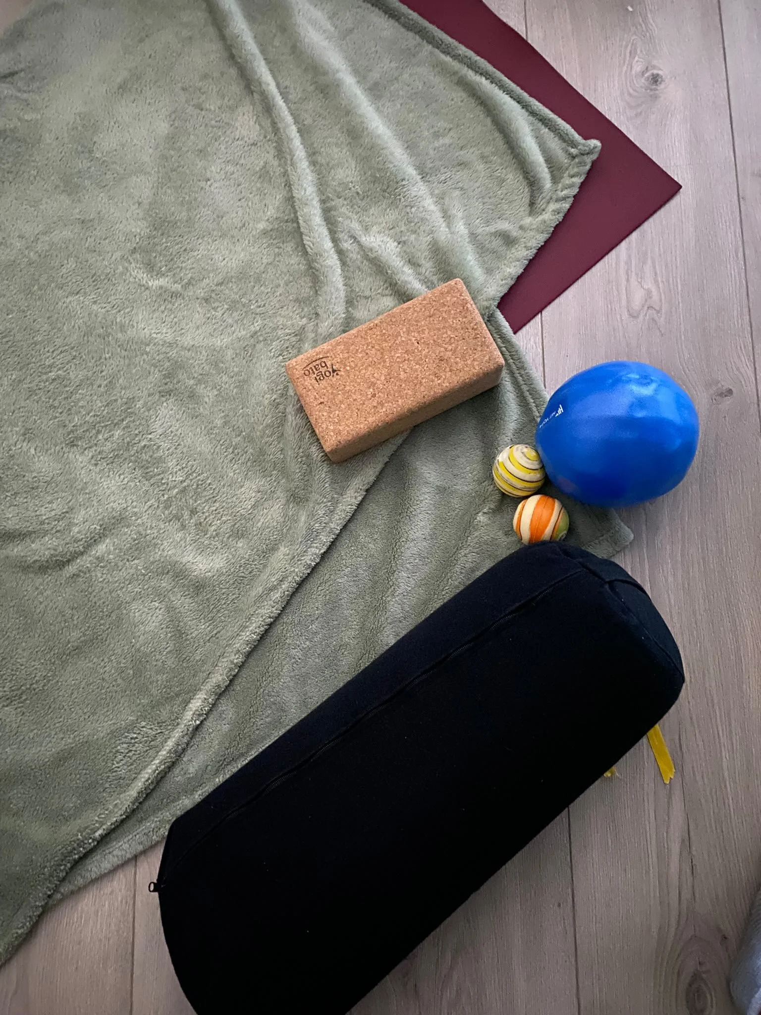 An example of props used in Fascia Focused Practice - a pair of therapy balls, a yoga block, a soft blow-up ball, yoga mat, blanket and a bolster.
