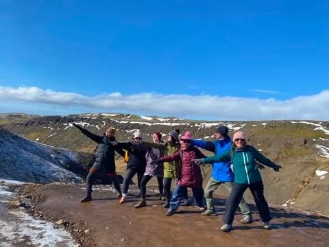 Group doing yoga poses whilst exploring the Icelandic landscape during the StinuYoga yoga adventure.