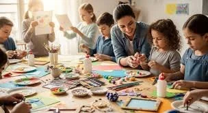 Children and an adult creating arts and crafts at a table in a classroom.