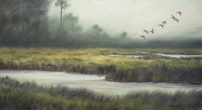 A wetland landscape with water, tall grass, trees in the distance, and birds flying in the sky.