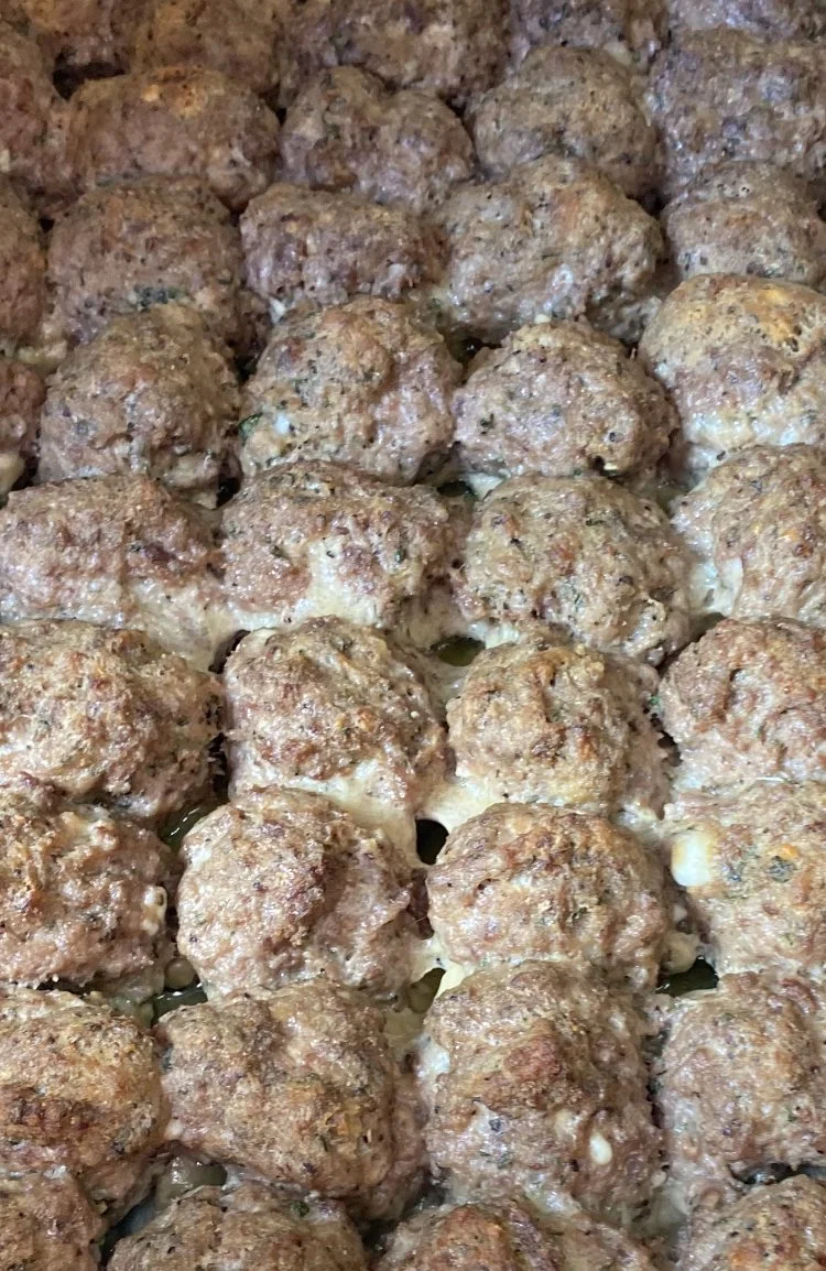 Close-up of cooked meatballs stacked closely together.