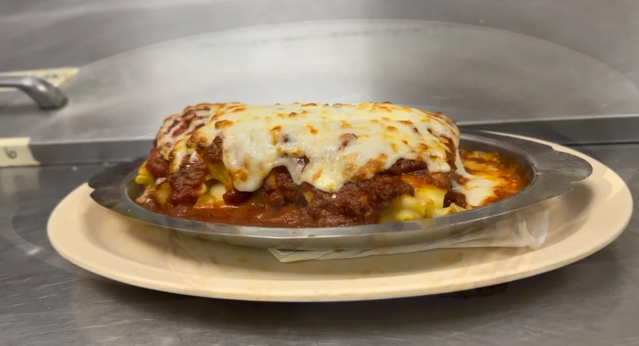 A plate of baked lasagna with melted cheese on top