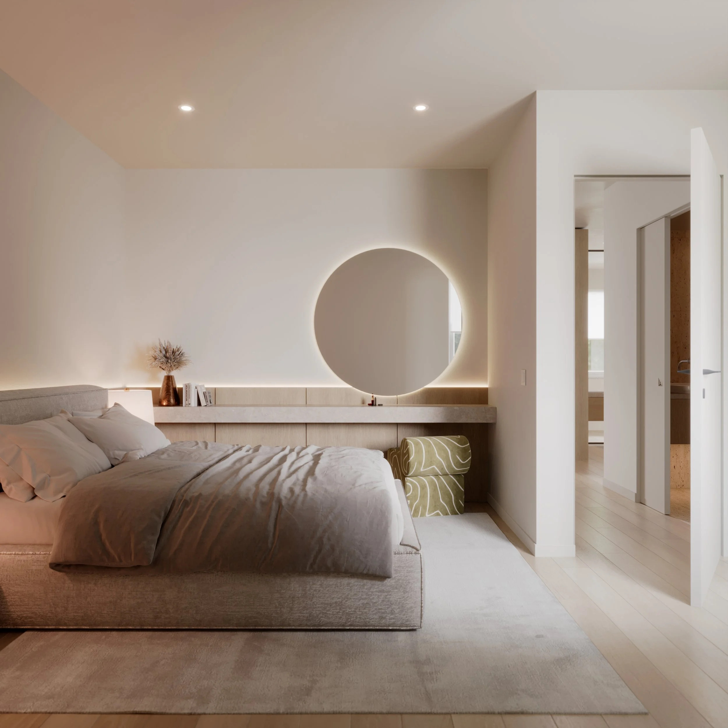 Modern bedroom with a neutral color palette, featuring a bed with beige bedding, a round illuminated mirror on the wall, and a small green bench at the foot of the bed. There is a floating shelf with books and a vase with dried flowers behind the bed