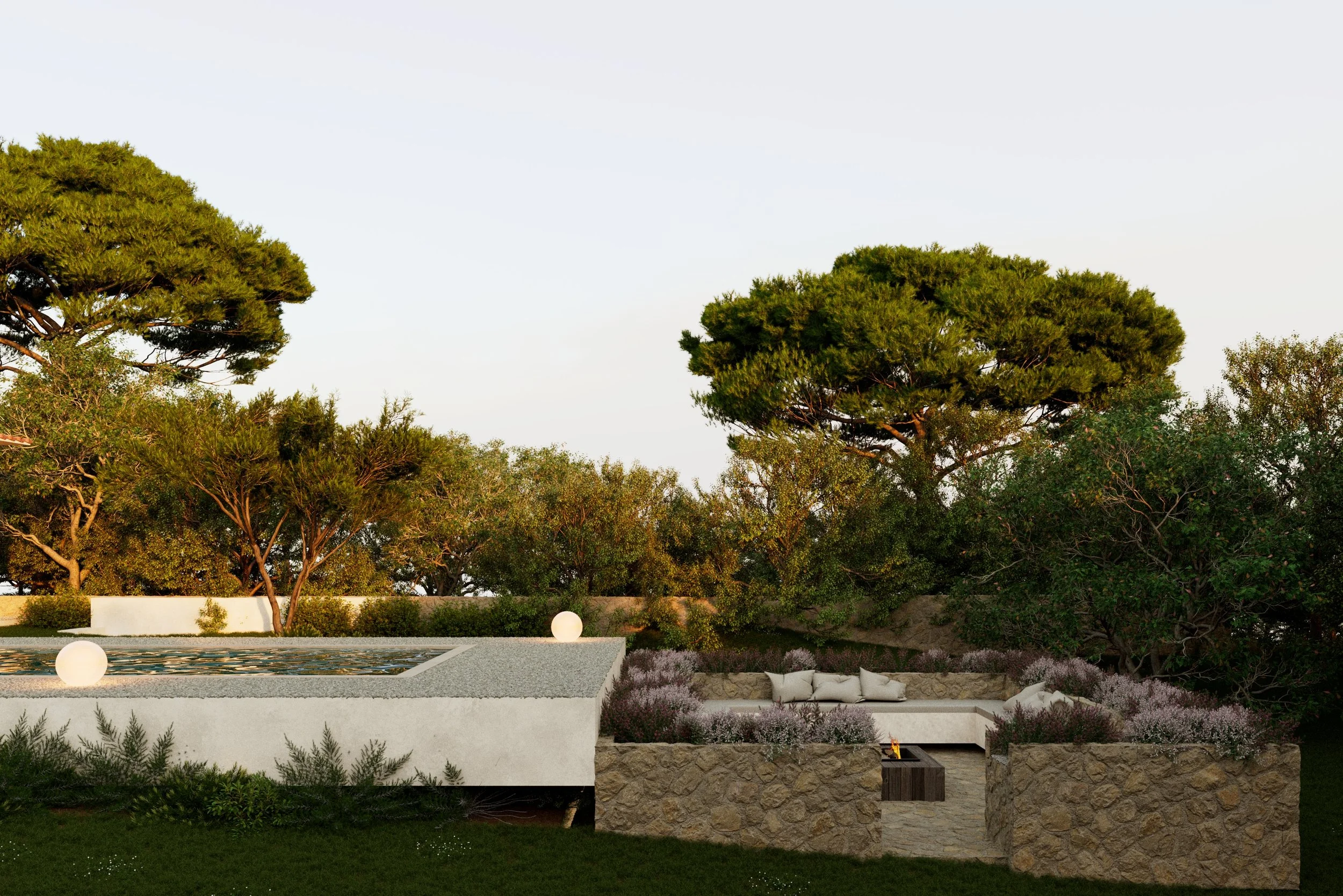 An outdoor patio with a built-in rectangular fire pit surrounded by flowering plants, with trees and shrubs in the background and night lights on the edge of the patio.