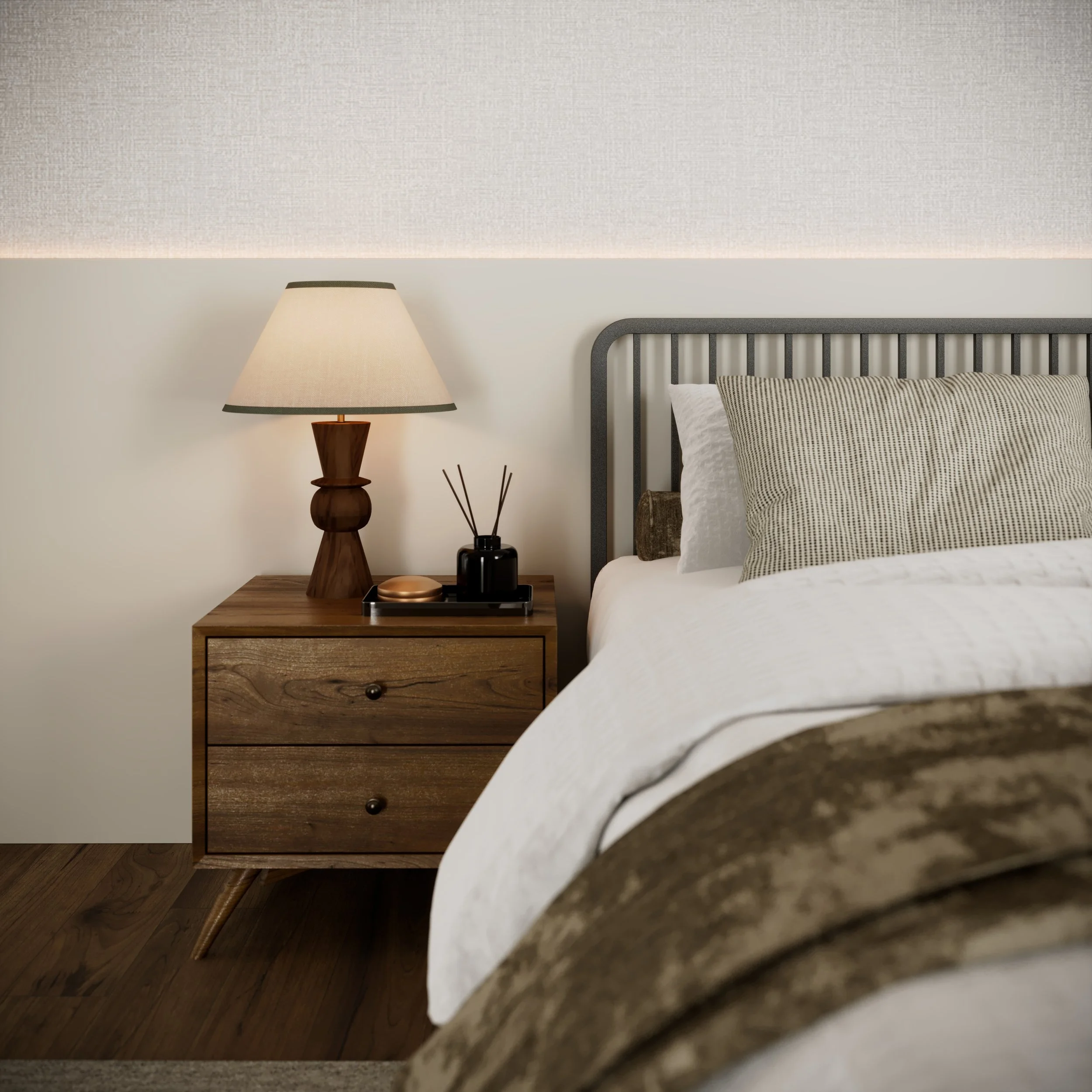 A cozy bedroom with a wooden nightstand, table lamp, and bed with striped pillows and a plush blanket.