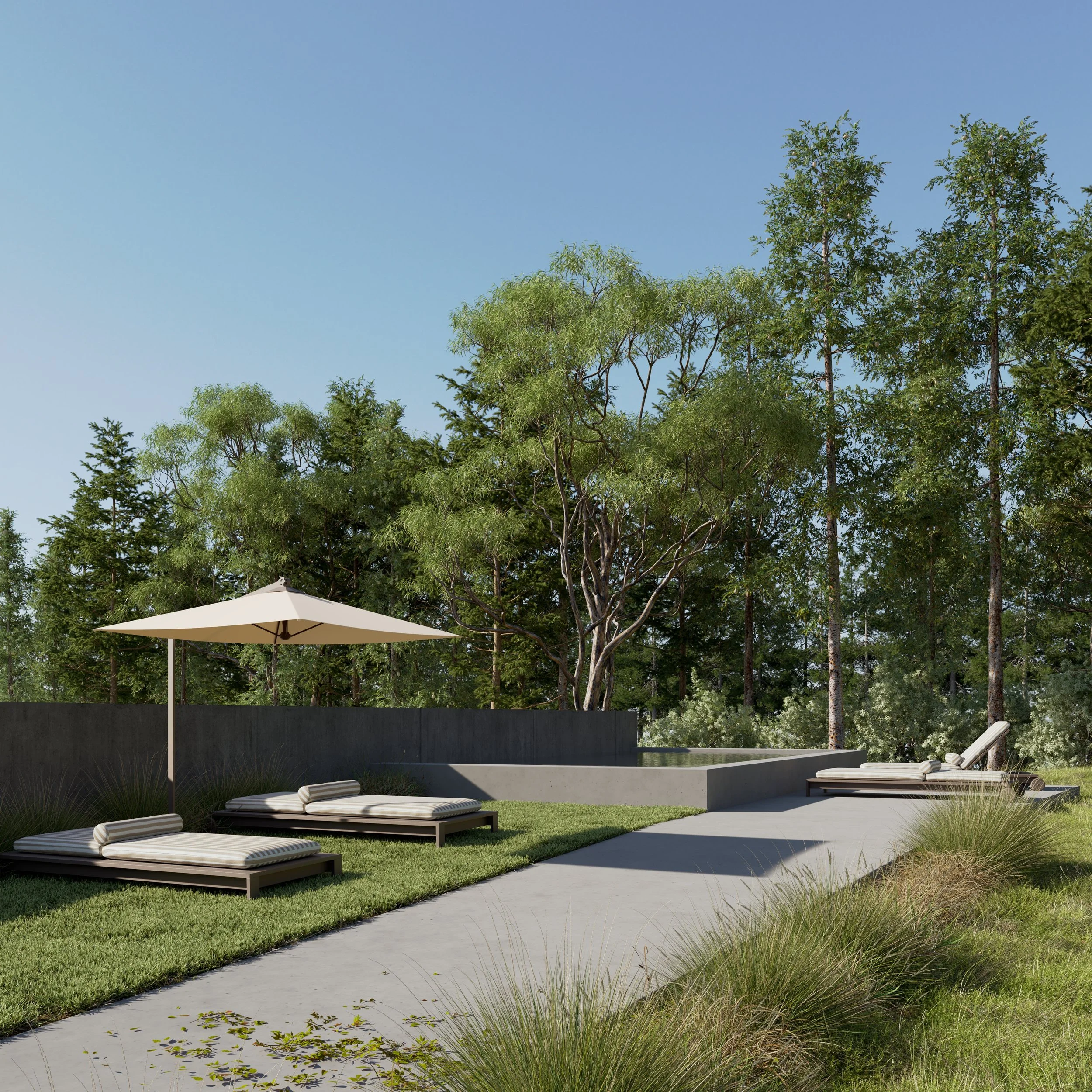 Outdoor patio area with lounge chairs, a large umbrella, a concrete pathway, and a background of green trees and shrubs under a clear blue sky.