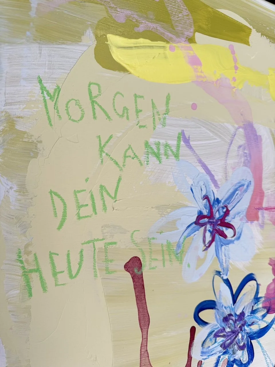Fröhliches, buntes Halloween-Gemälde mit grüner Inschrift 'Morgen kann dein heut' sein' und bunten Blumen auf pastellfarbenem Hintergrund.