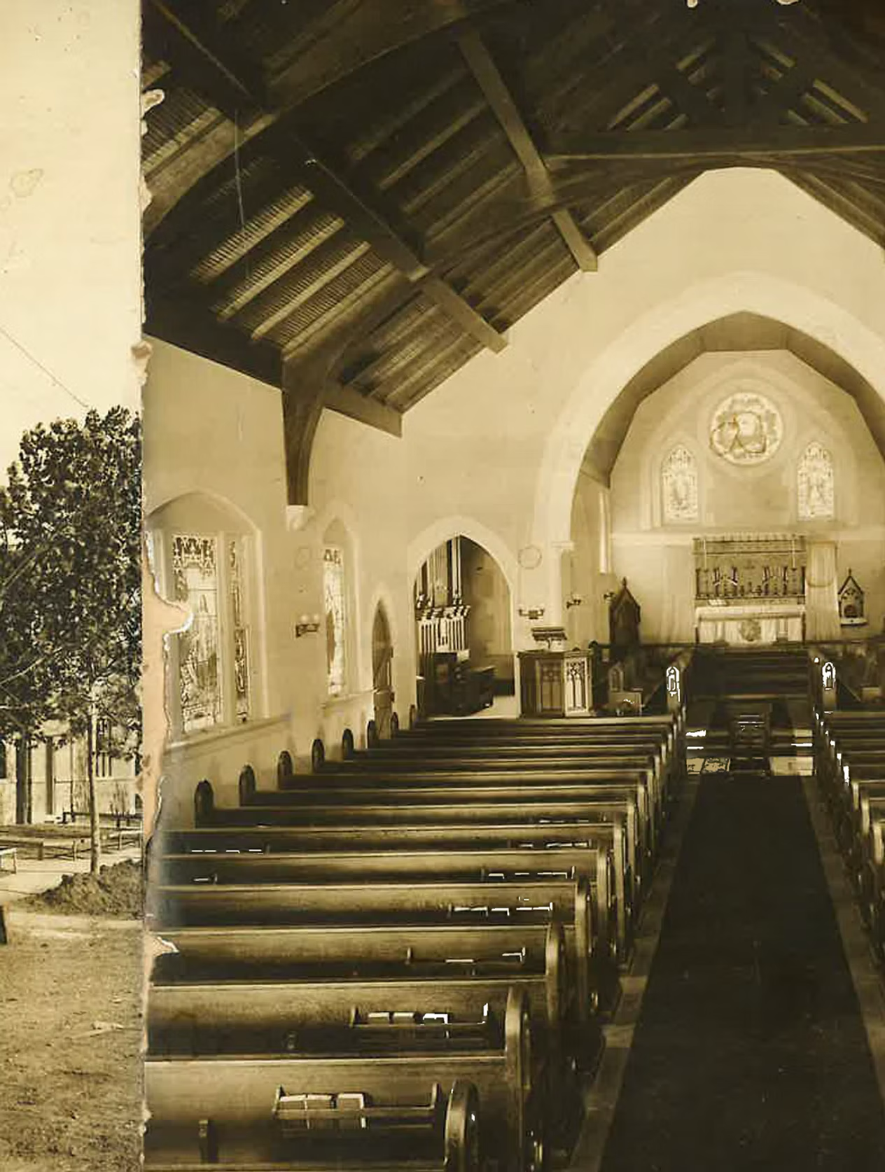 Interior view of a church with wooden pews, stained glass windows, and an altar at the front. The church features a high, arched ceiling with dark wooden beams.