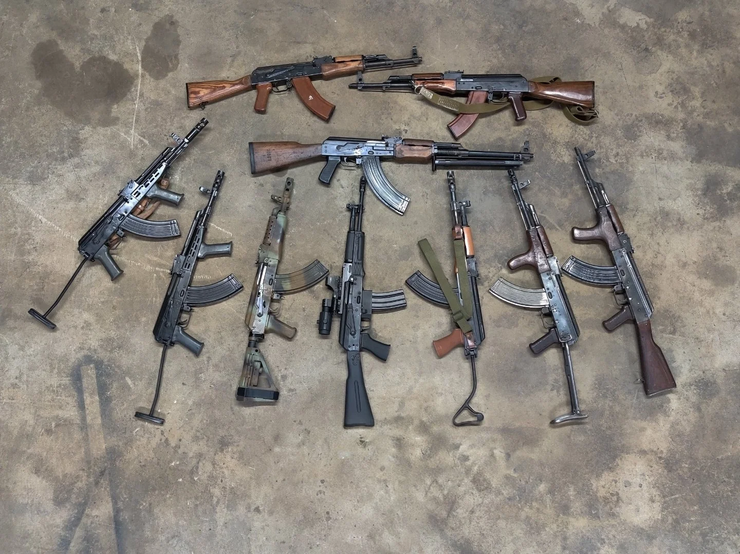 Collection of AR and AK rifle builds by Nexus Defense & Machine Co on workshop floor