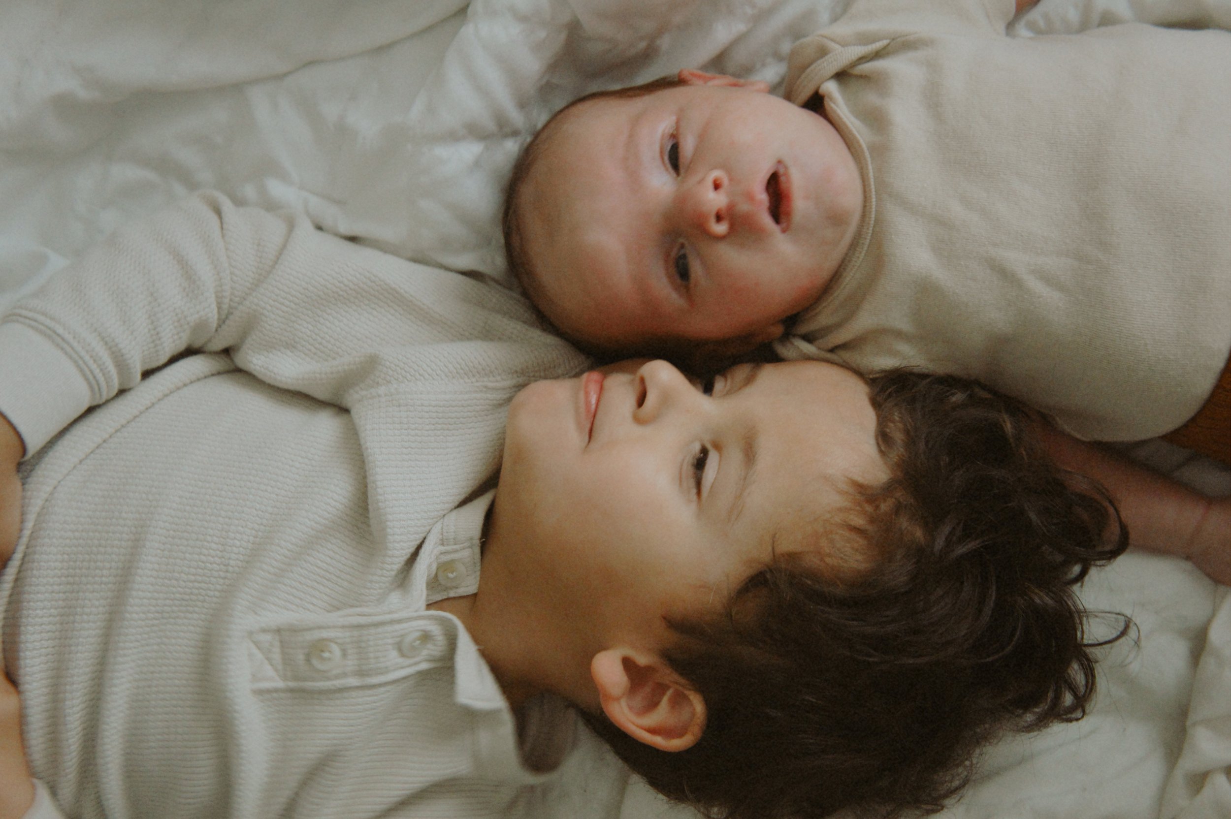 A bride and groom sharing a moment outdoors during their wedding ceremony, with the bride holding a bouquet of flowers and the groom embracing her.