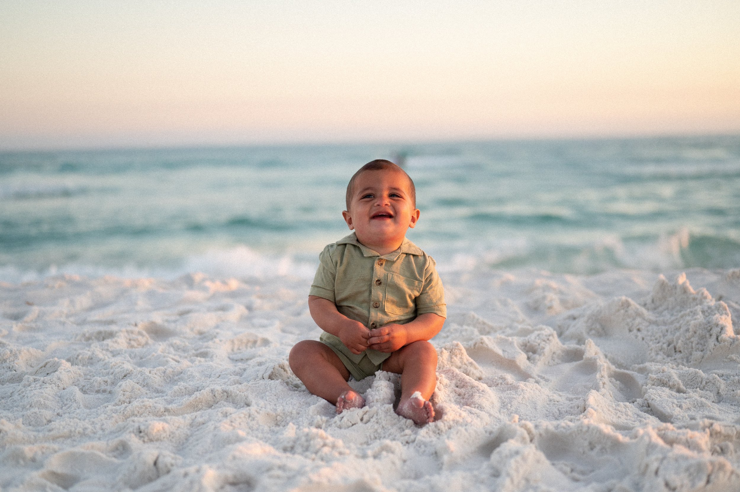 Several wooden chairs with white cushions arranged outdoors on green grass.