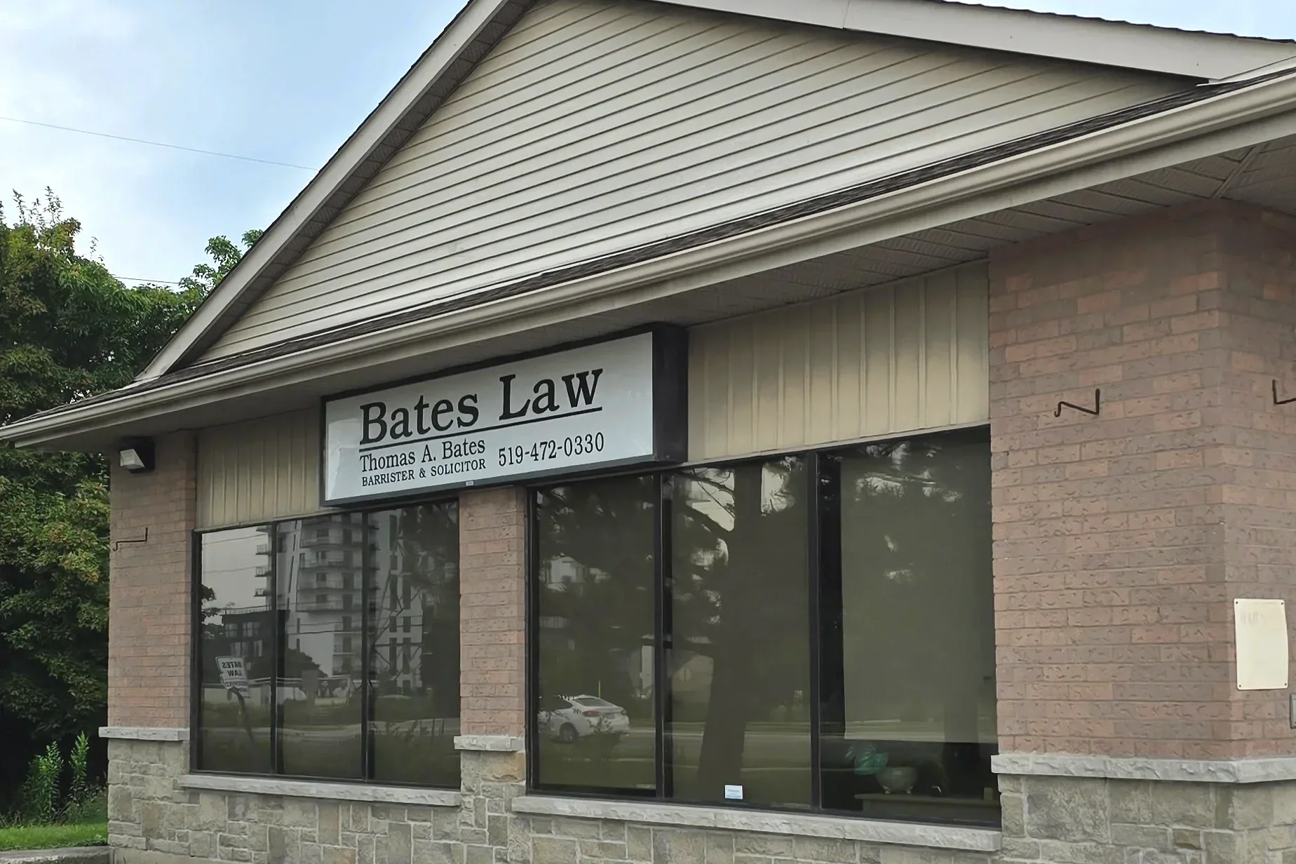 Image of the Bates Law, real estate and estate law office in Westmount at Pine Valley Blvd and Southdale; the sign on the stone, brick and siding front, above large glass windows reads: Bates Law, Thomas A. Bates, Barrister & Solicitor, 519-472-0330.
